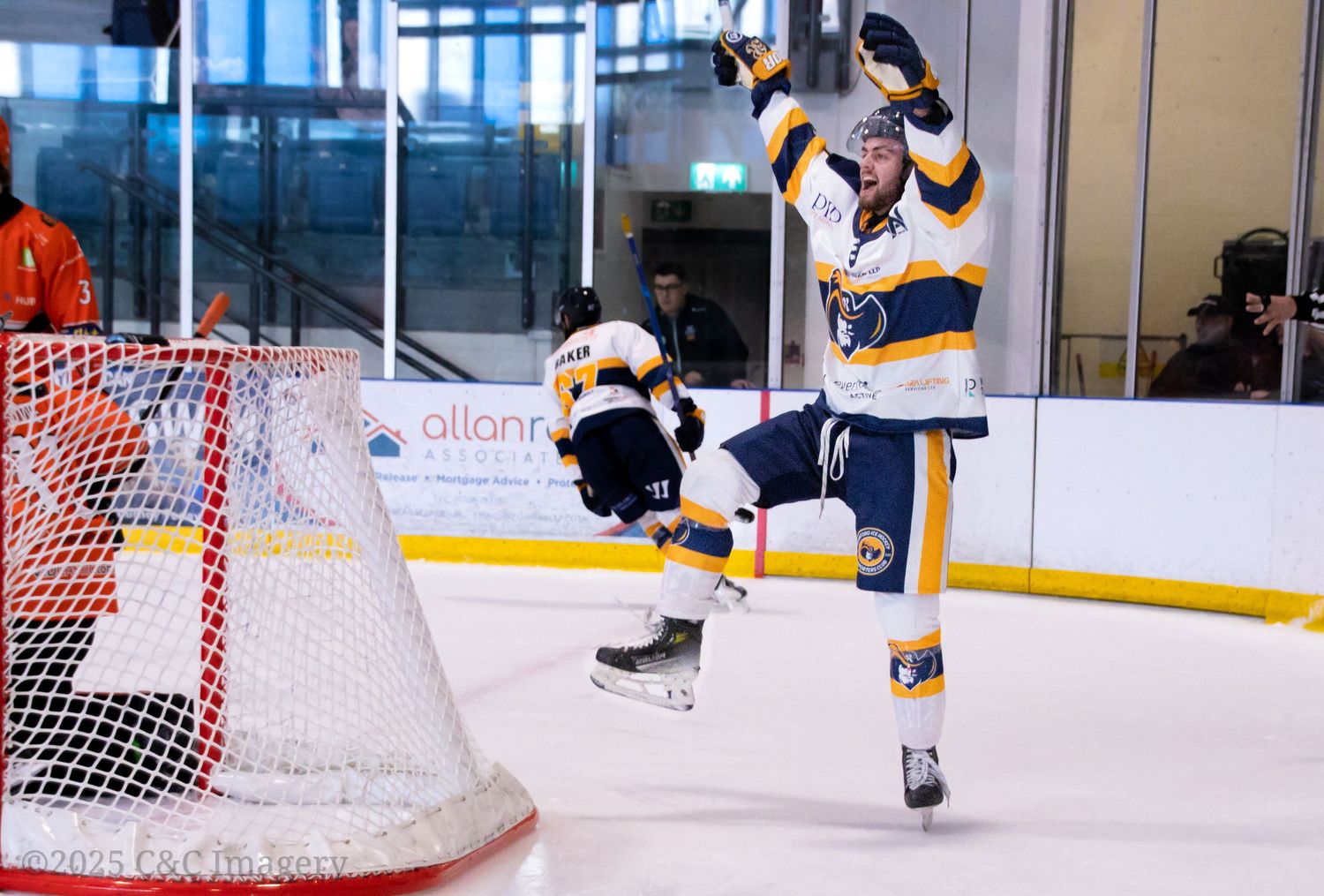 Hockey players on ice rink with goal nets visible in action sequence.
