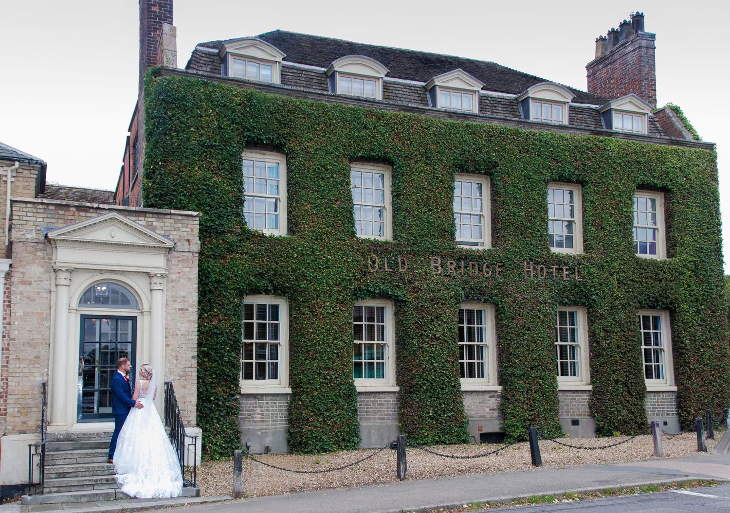 Historic ivy-covered Georgian building facade with white windows and doors creates elegant architectural composition.