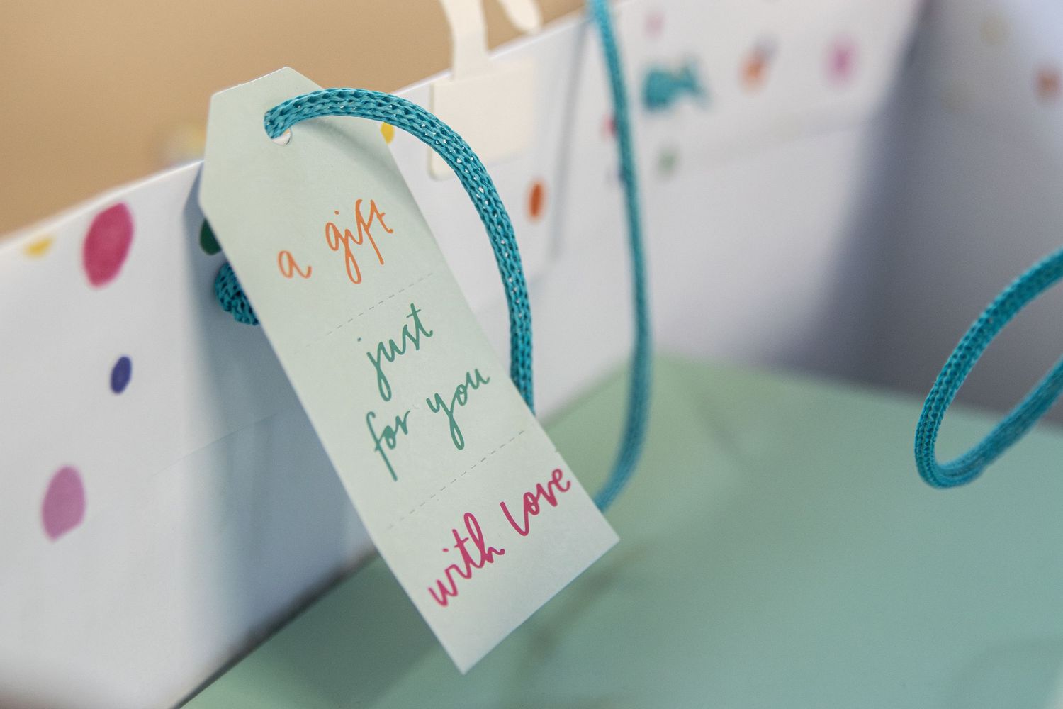 Gift bag with handwritten tag reading a gift just for you with love in colorful ink.