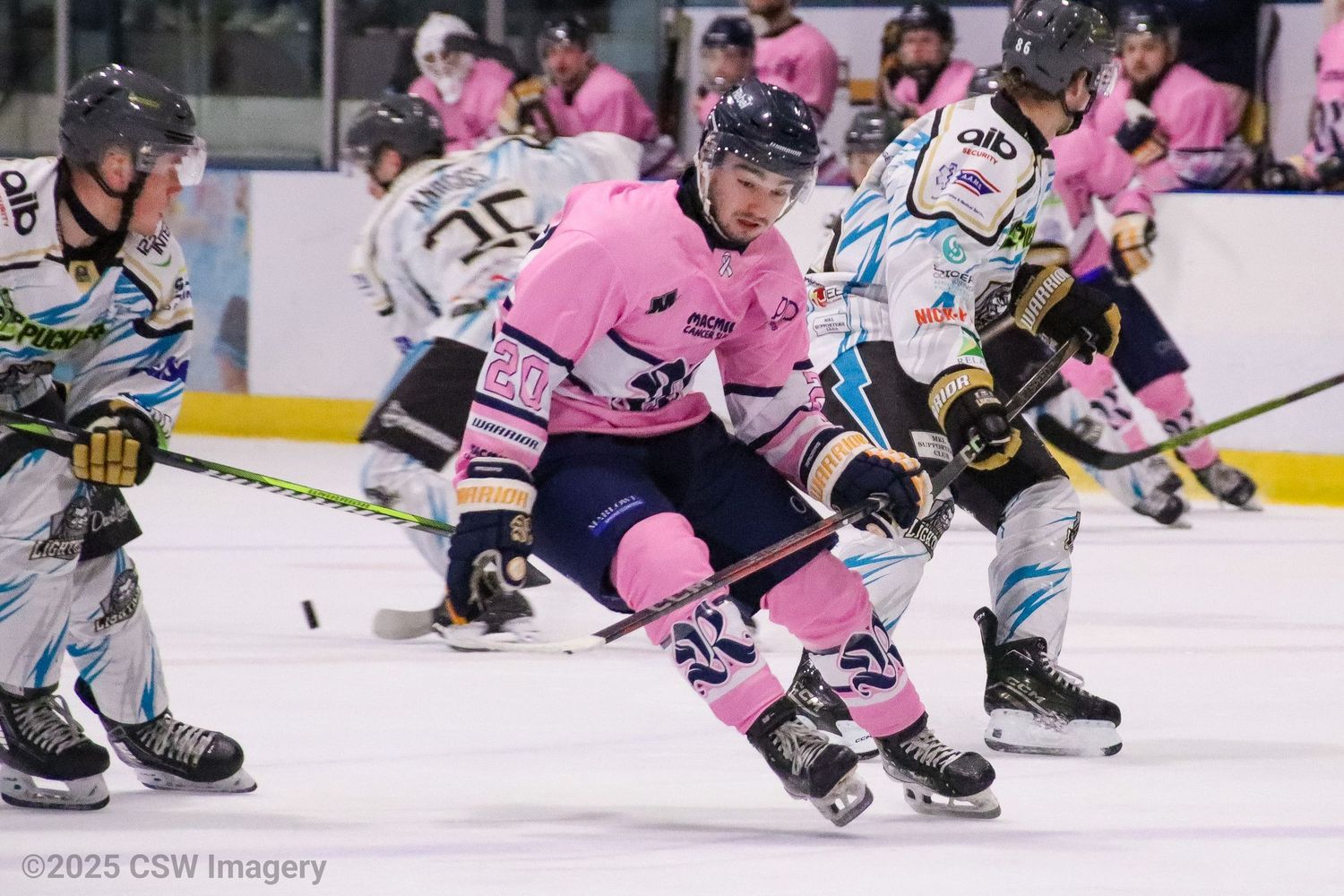 Hockey players in pink jerseys compete on ice during a special themed game.