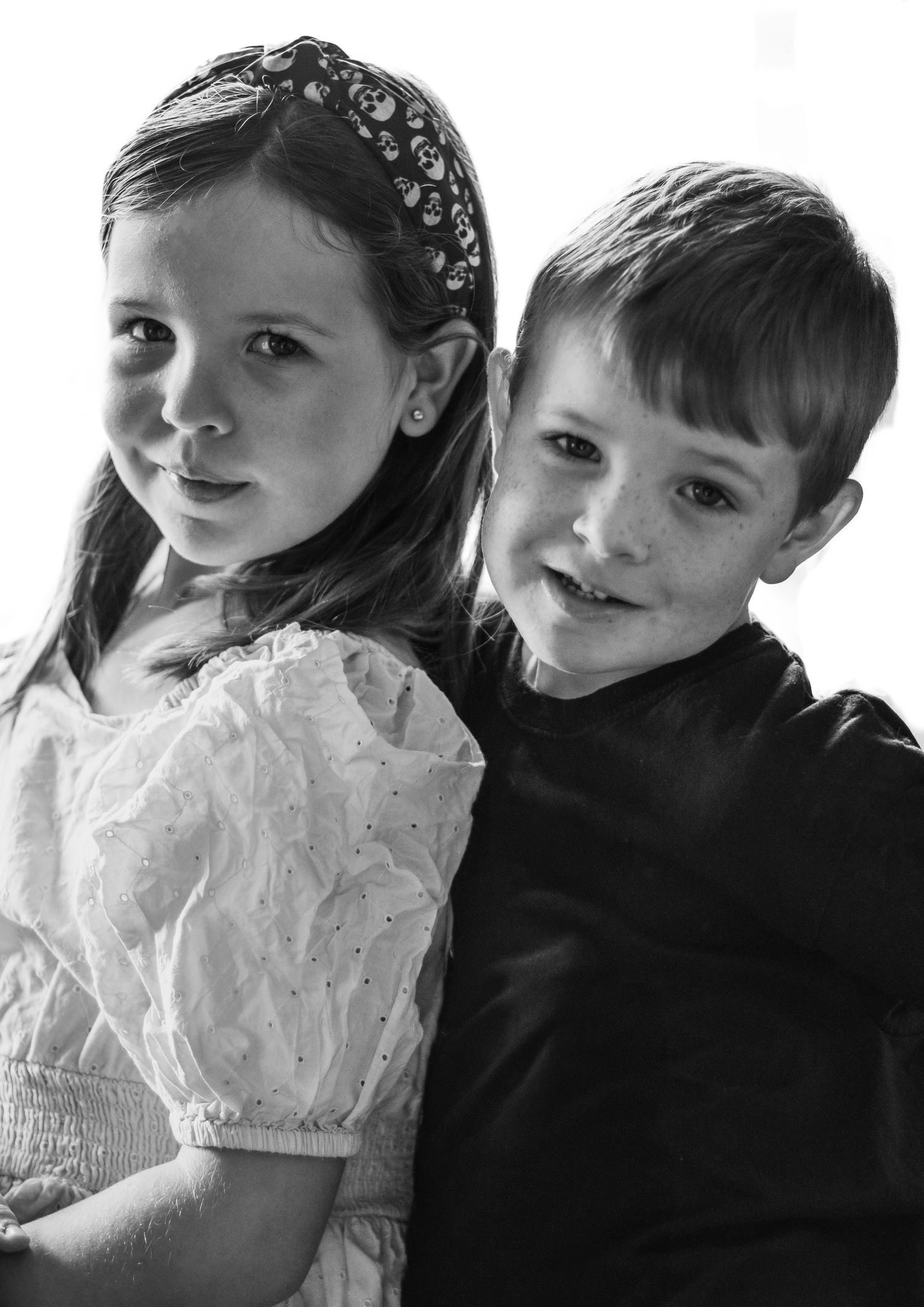 Portrait of children in formal attire against white background.