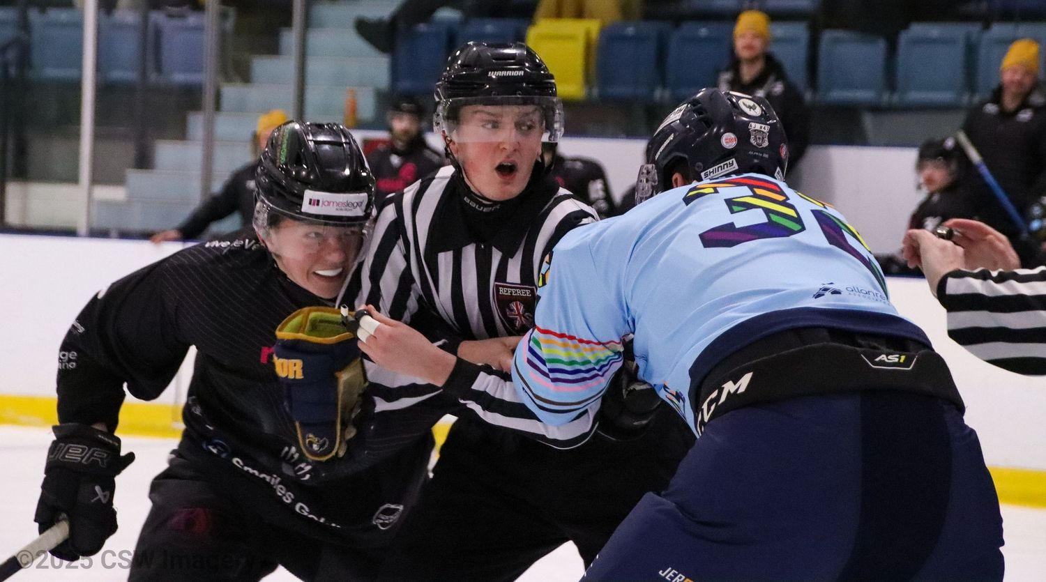 Action shot of hockey players battling for position during an intense game moment.
