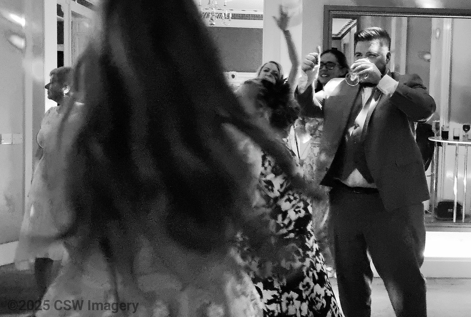 Indoor dance celebration with people moving on a dance floor.