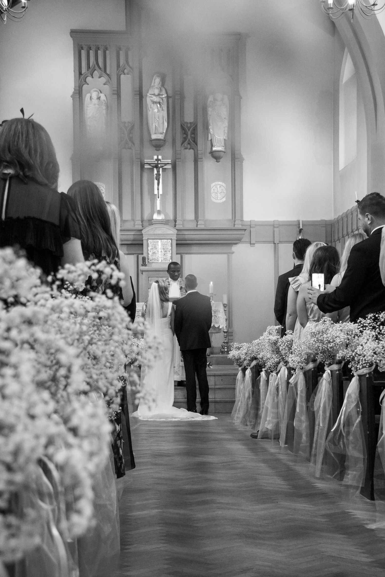 Black and white photo series showing a church wedding ceremony aisle decorated with floral arrangements and white bows.