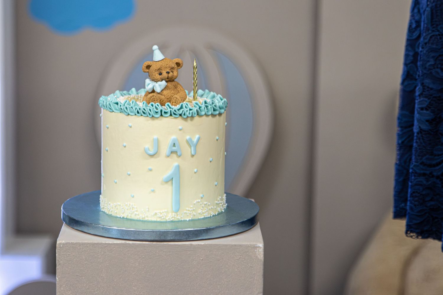 First birthday cake for Jay with teddy bear topper and blue number one decoration.