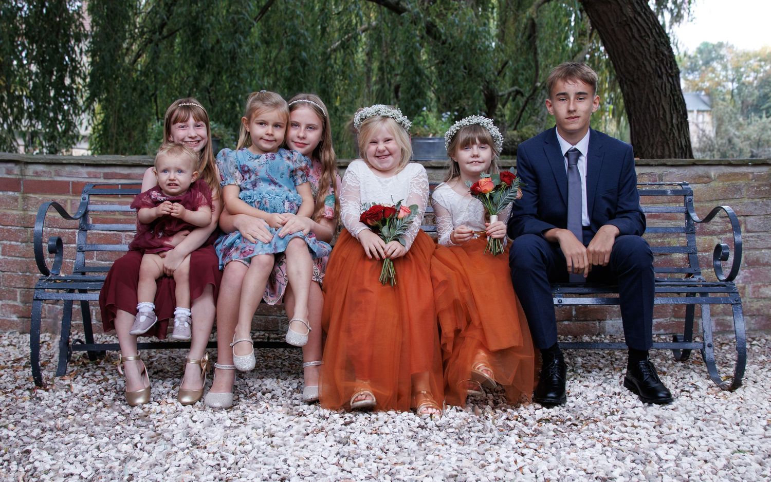 A series of family portraits showing children sitting together on stone steps outdoors.