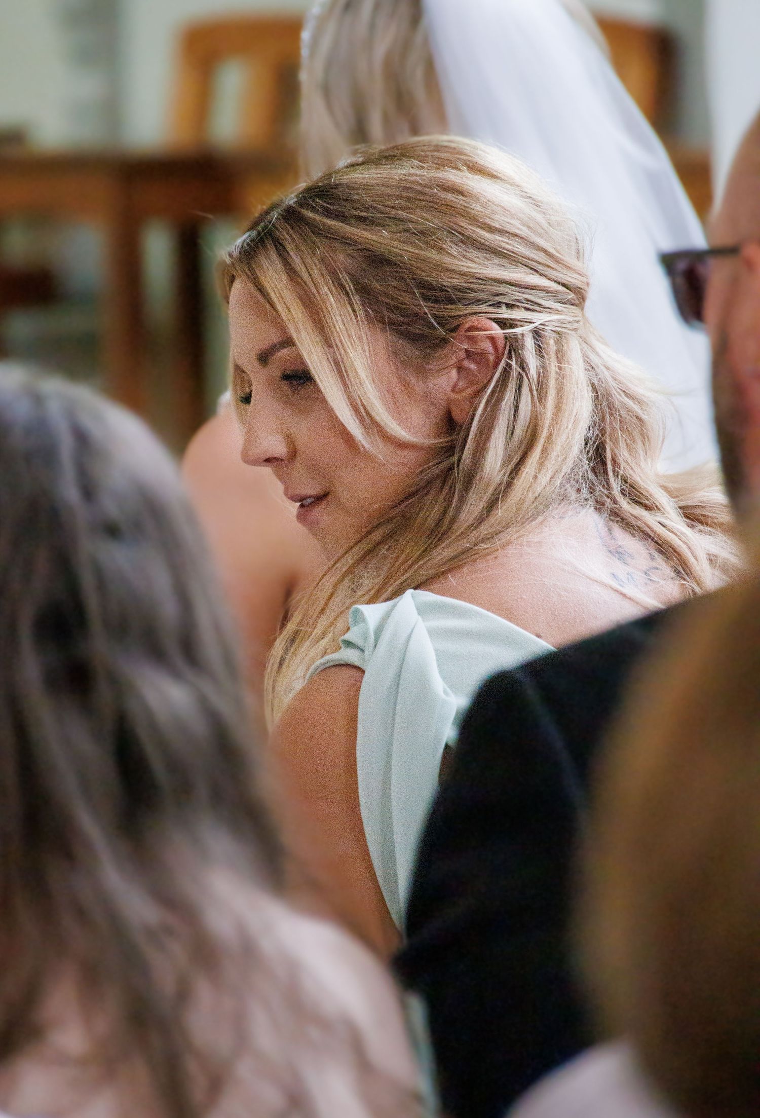 Side profile view of someone with blonde hair at a formal event.
