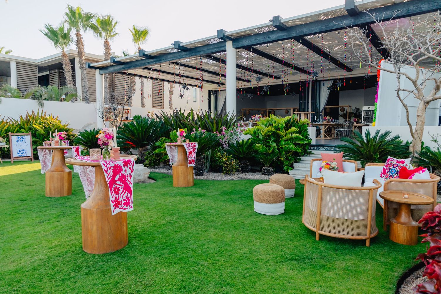Elegant outdoor seating area with cream-colored lounge furniture and palm trees.