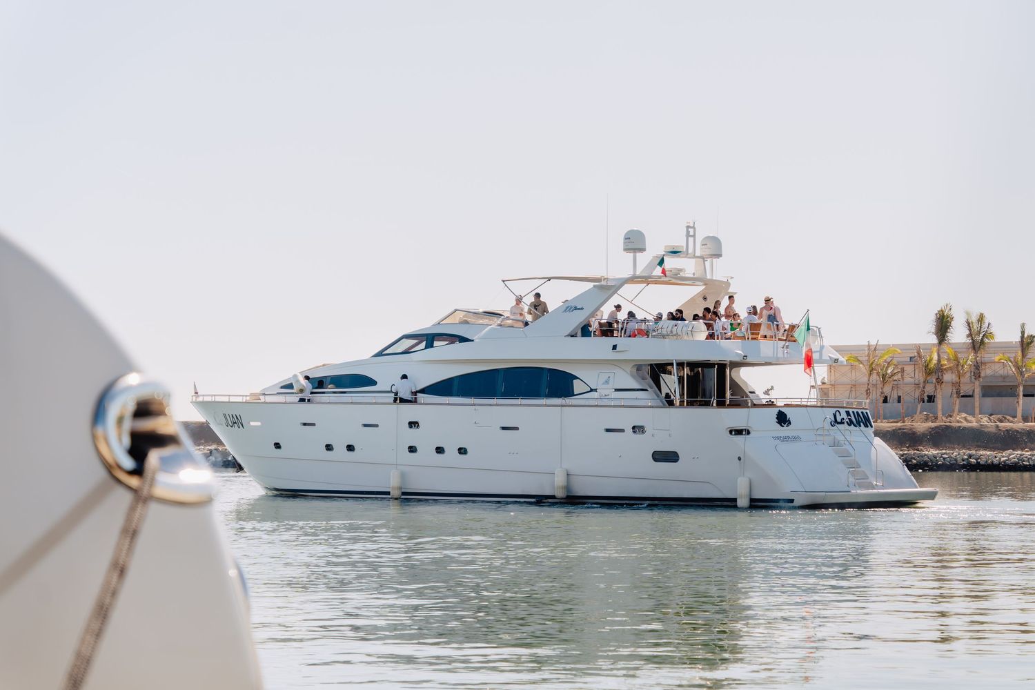 Multiple luxury yachts anchored in a scenic harbor with clear skies.