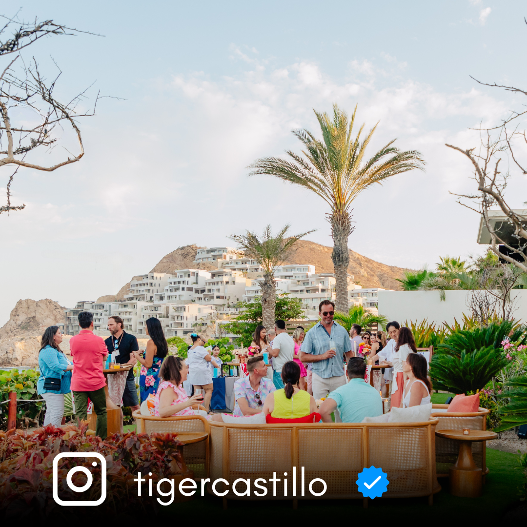 Wedding celebration with guests in colorful attire on an oceanfront terrace.