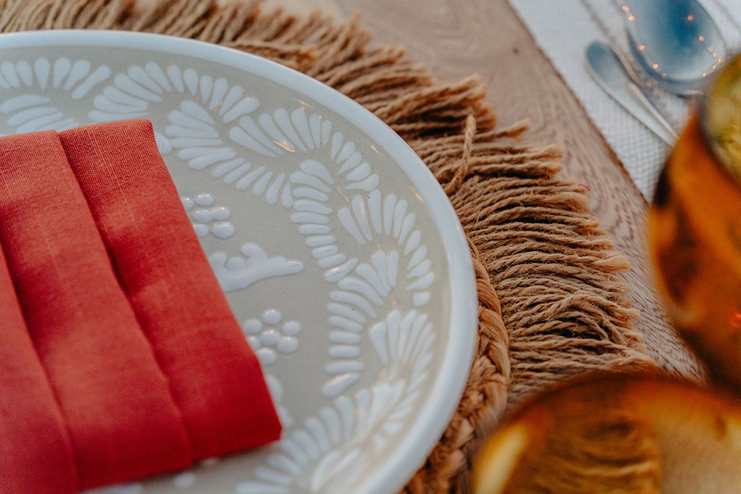 Close up of delicate rose petals and candles creating a romantic sunset beach proposal setting.
