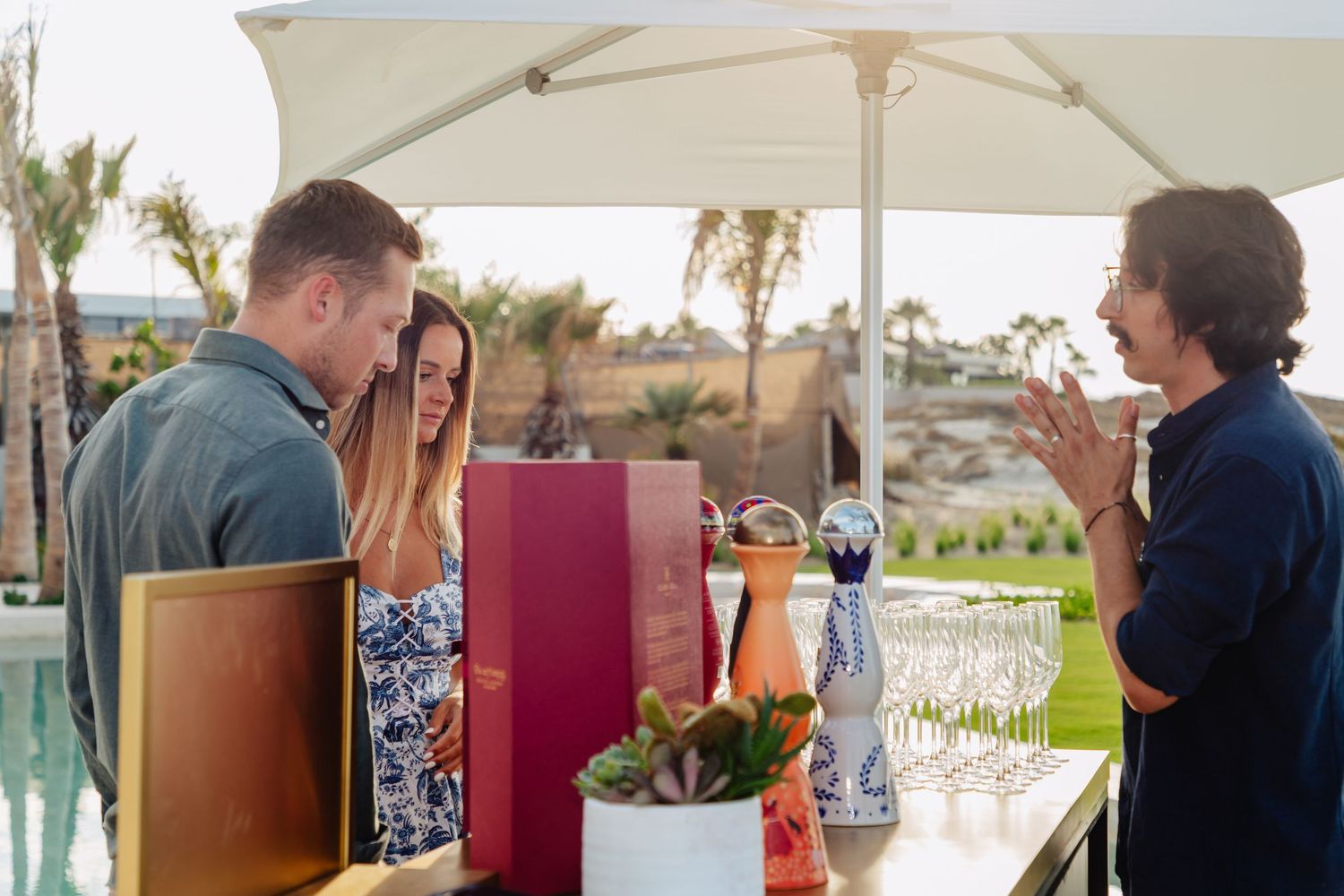 Modern outdoor bar setup with white umbrellas and professional bartending service.