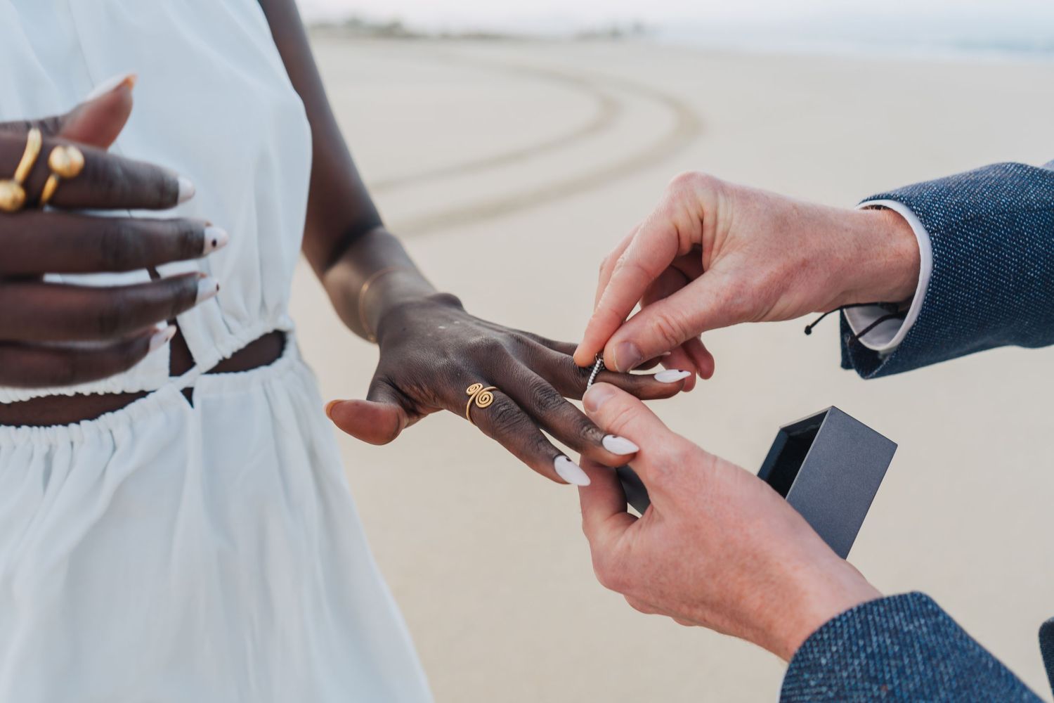 Series of photos showing hands exchanging an engagement ring during a proposal.