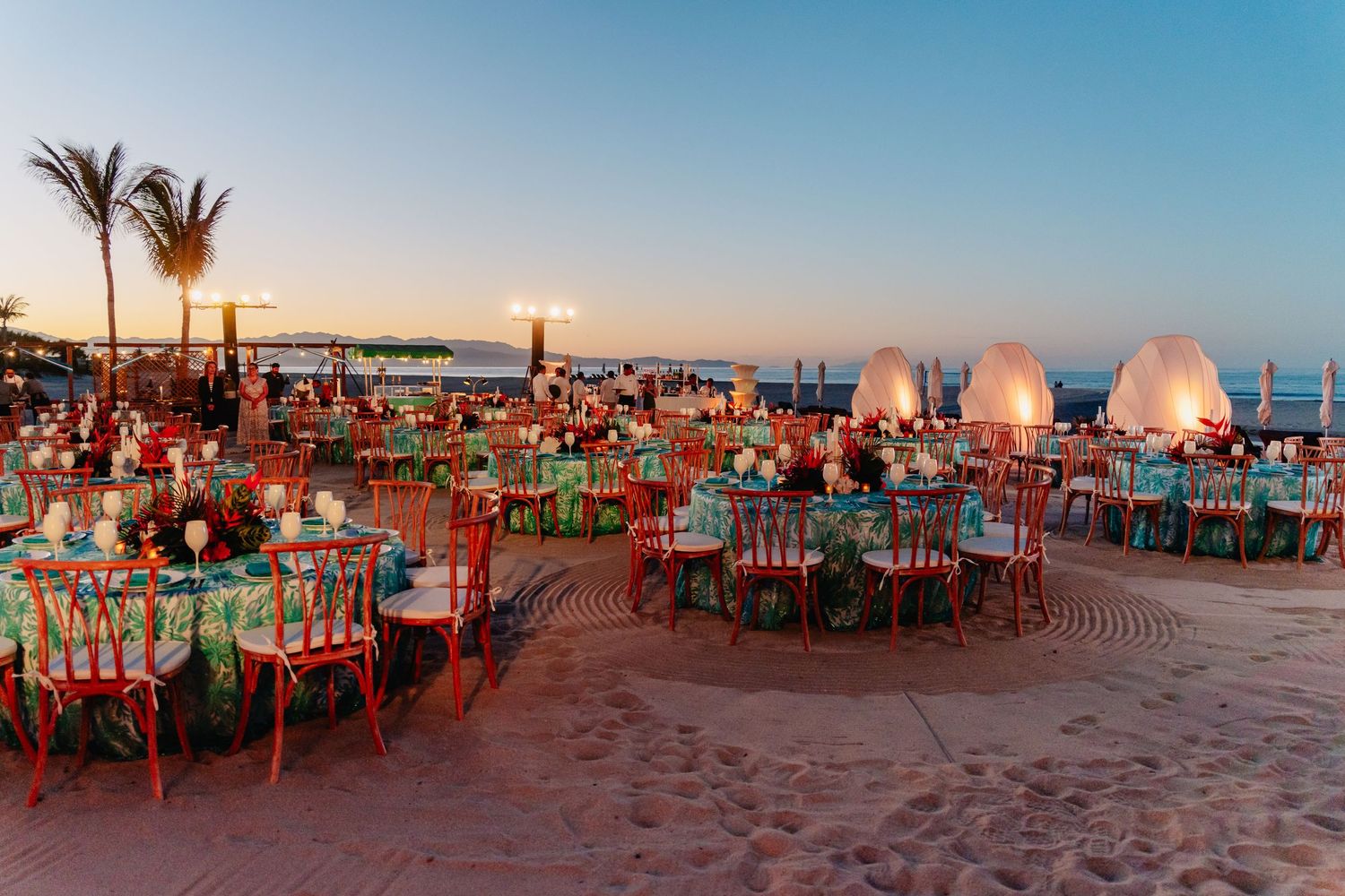 Panoramic sequence of a beachfront restaurant with red tables and chairs at sunset showing palm trees and ocean views.