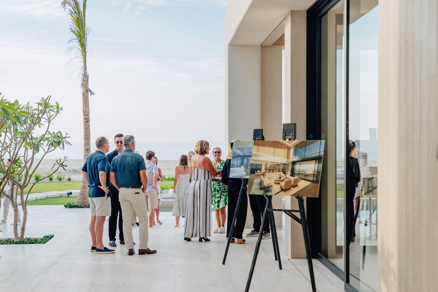 Modern beachfront venue with glass walls and palm trees in the background.