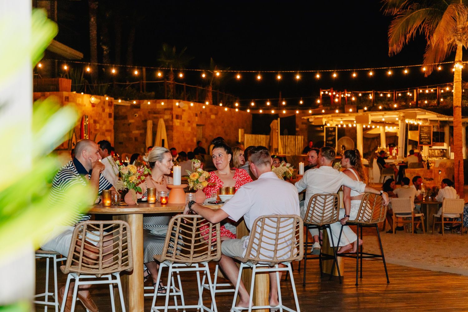 Evening outdoor dining area with string lights and modern chairs creating an intimate ambiance.
