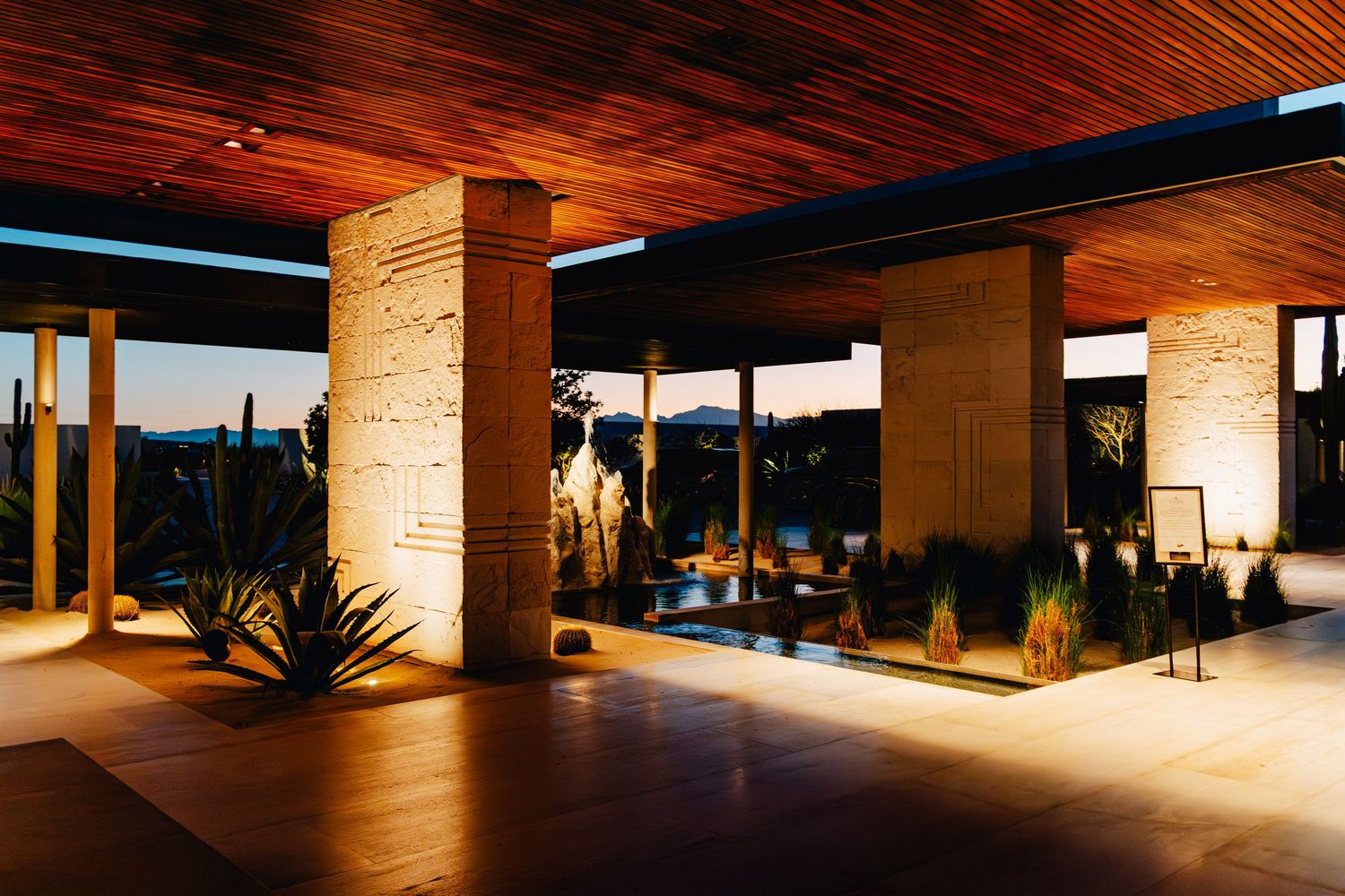 Modern wooden ceiling and ambient lighting create a warm atmosphere in an upscale resort hallway.