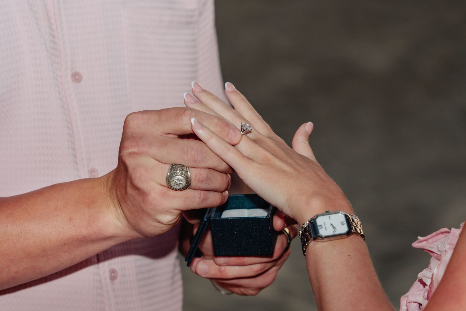 Close-up shot of hands during a ring exchange with a watch visible.