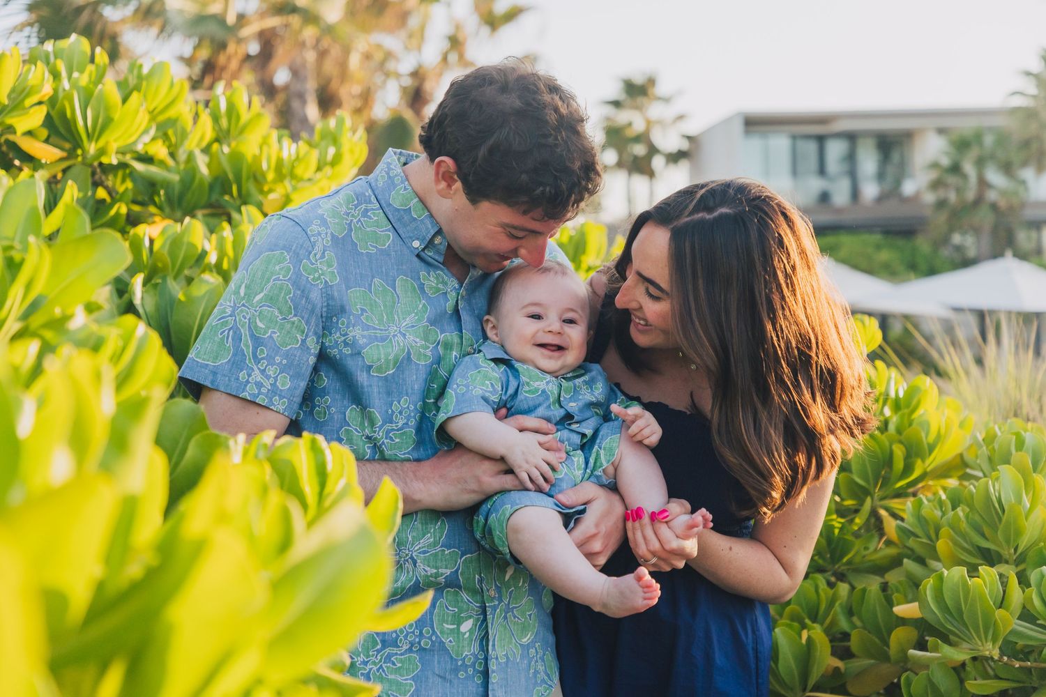 A family moment captured among lush tropical plants.