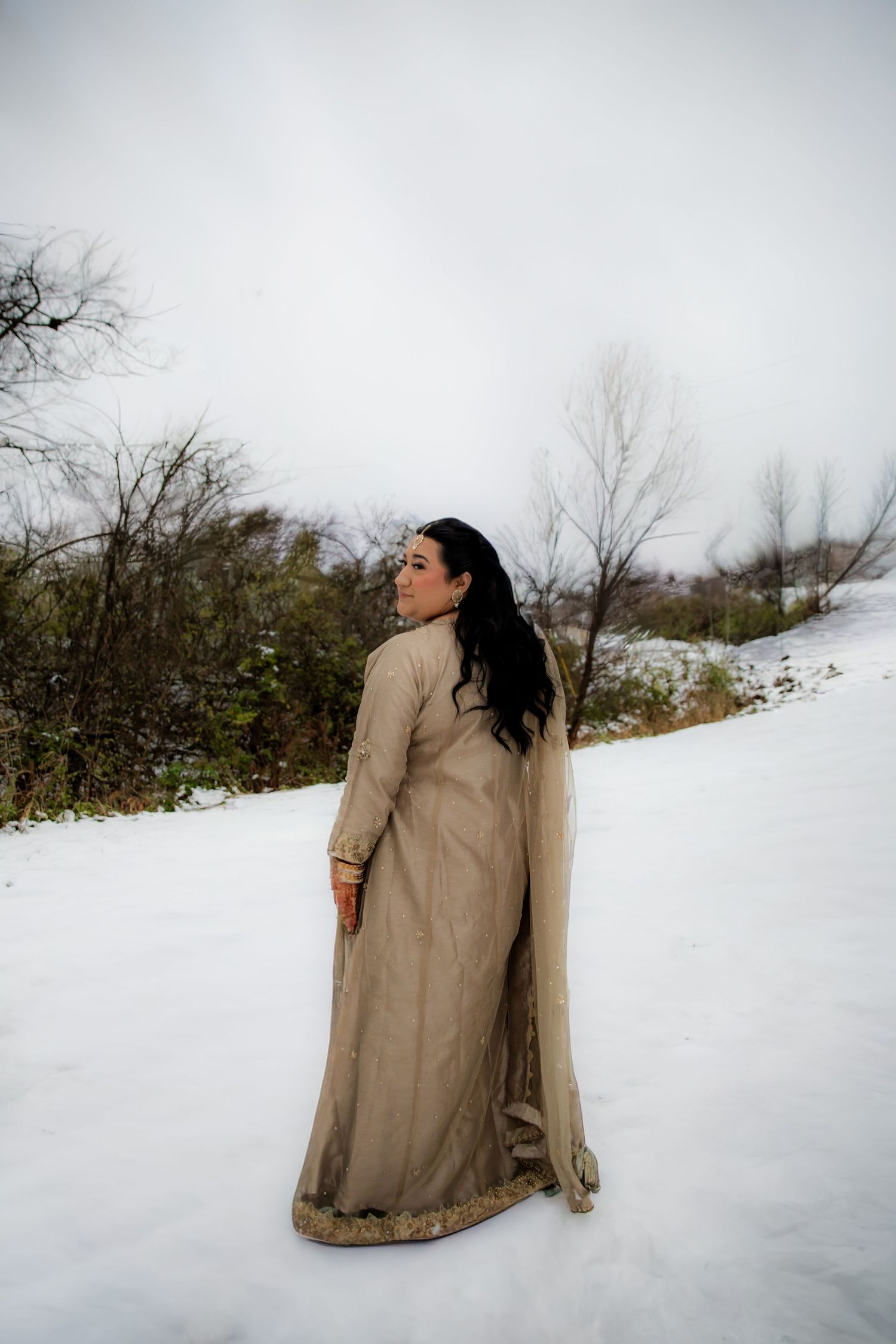 Bride looking over shoulder in snow