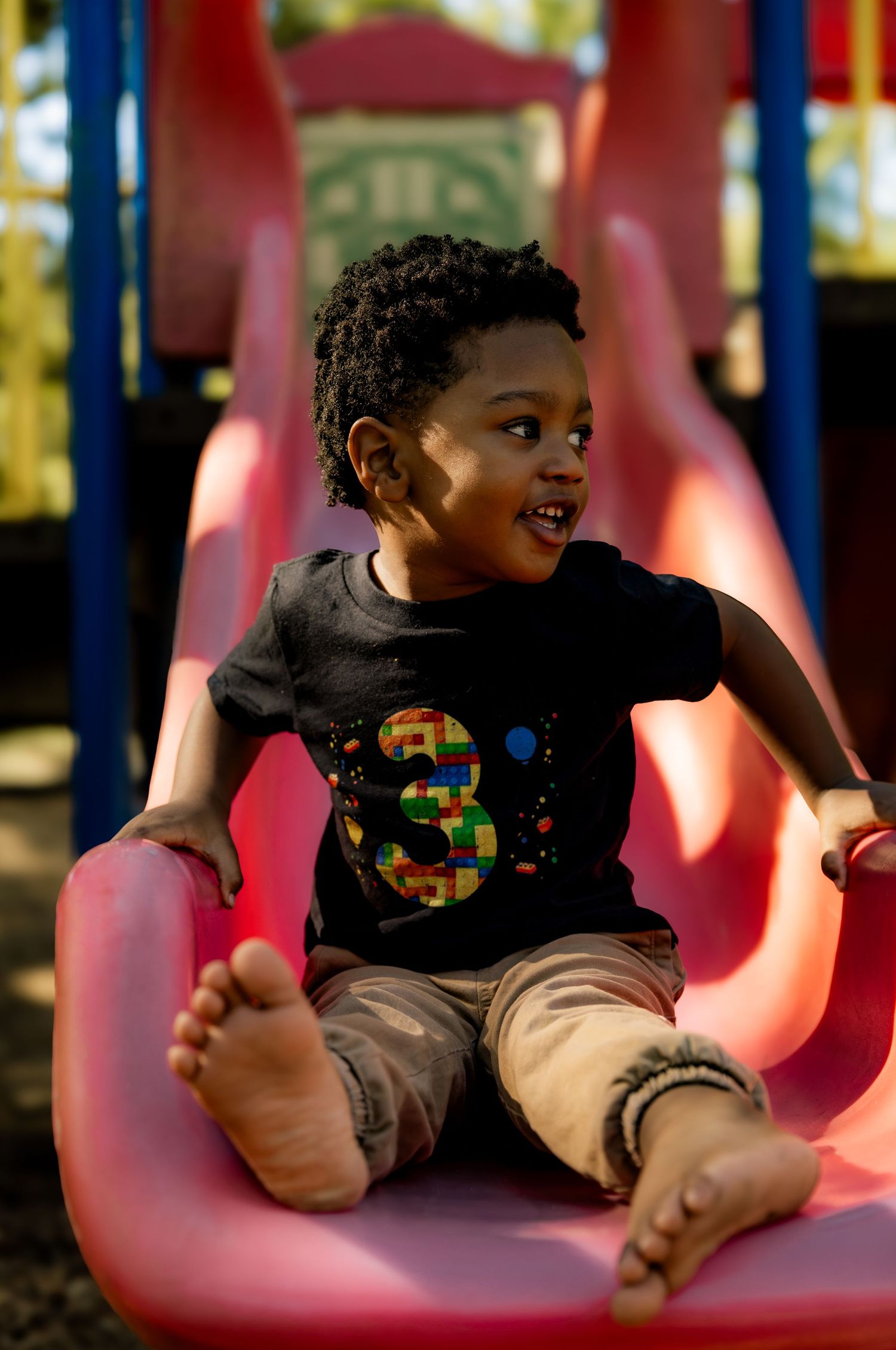 Boy smiling going down slide