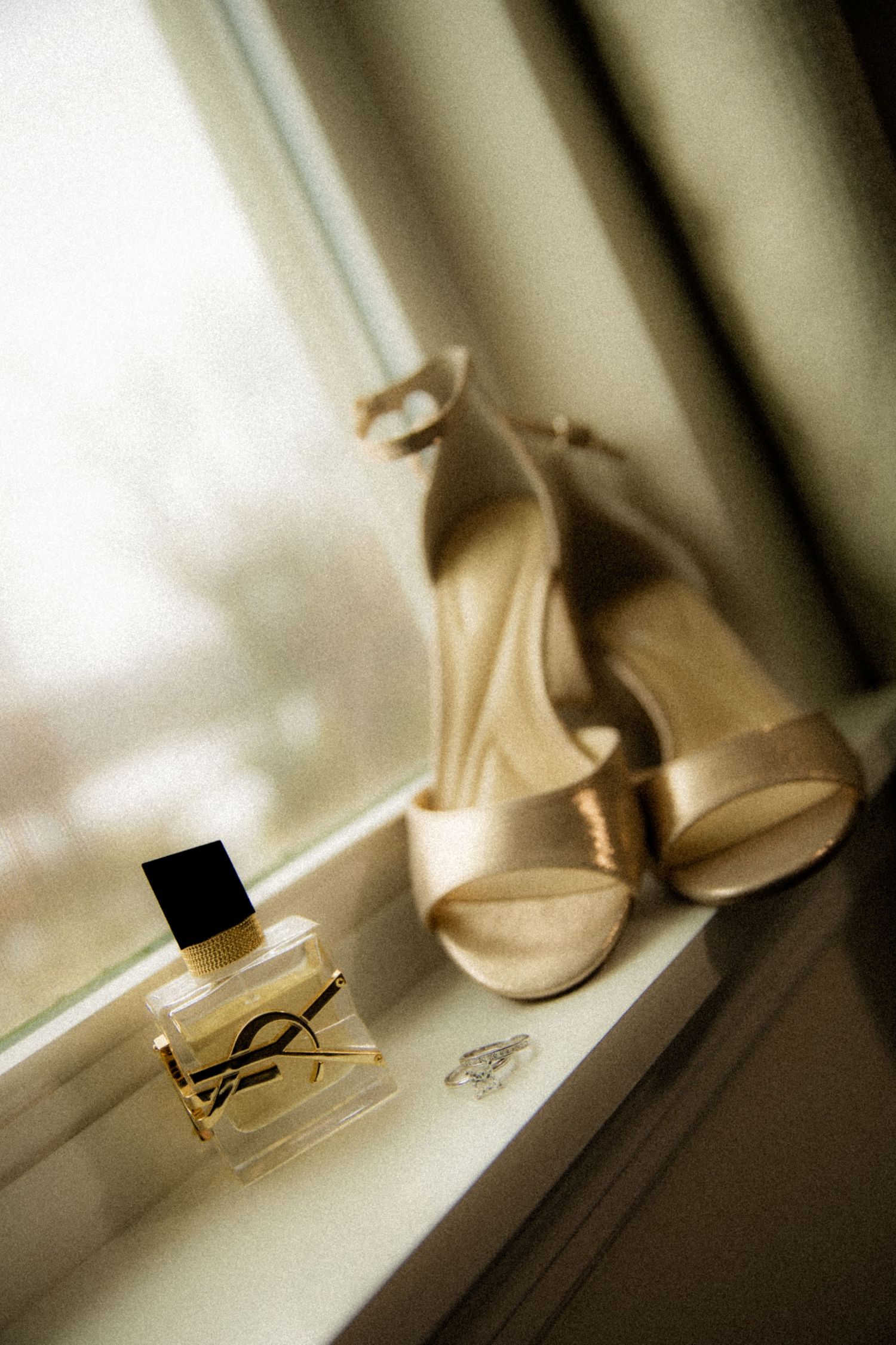Shoes in window with perfume and engagement ring