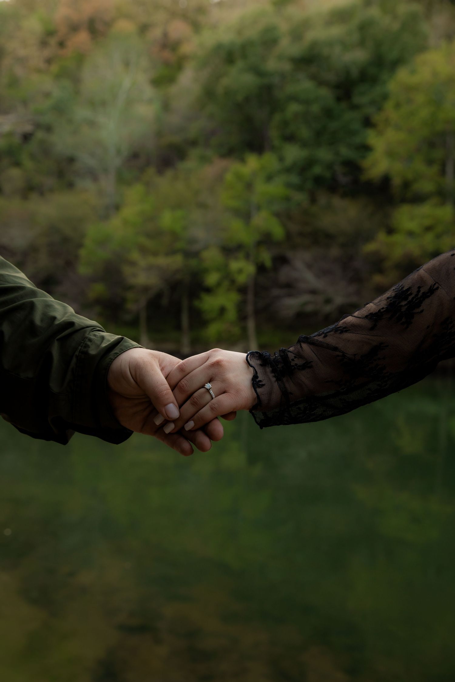 Holding hands showing round engagement ring