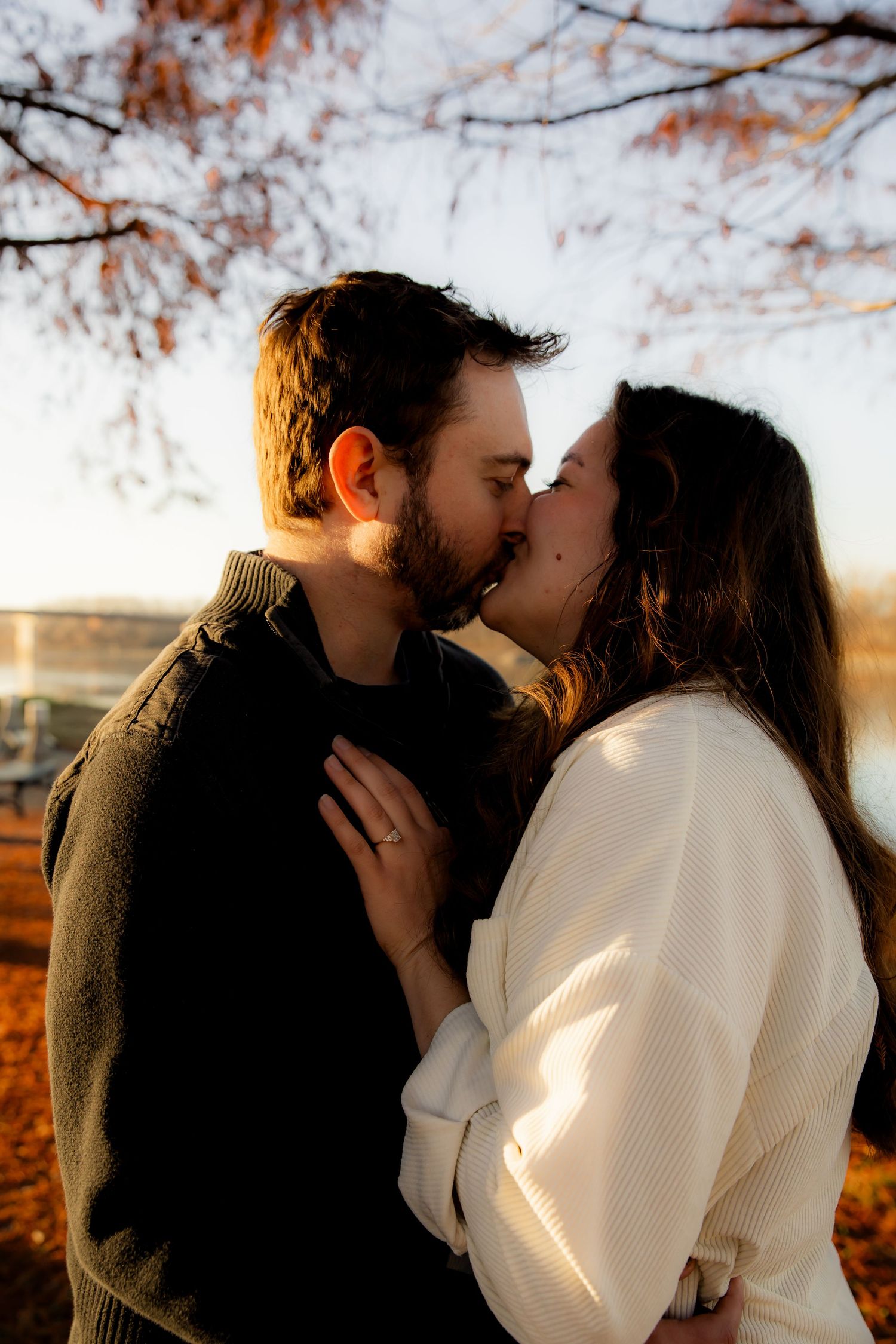 Kissing and having hand with engagement ring on chest