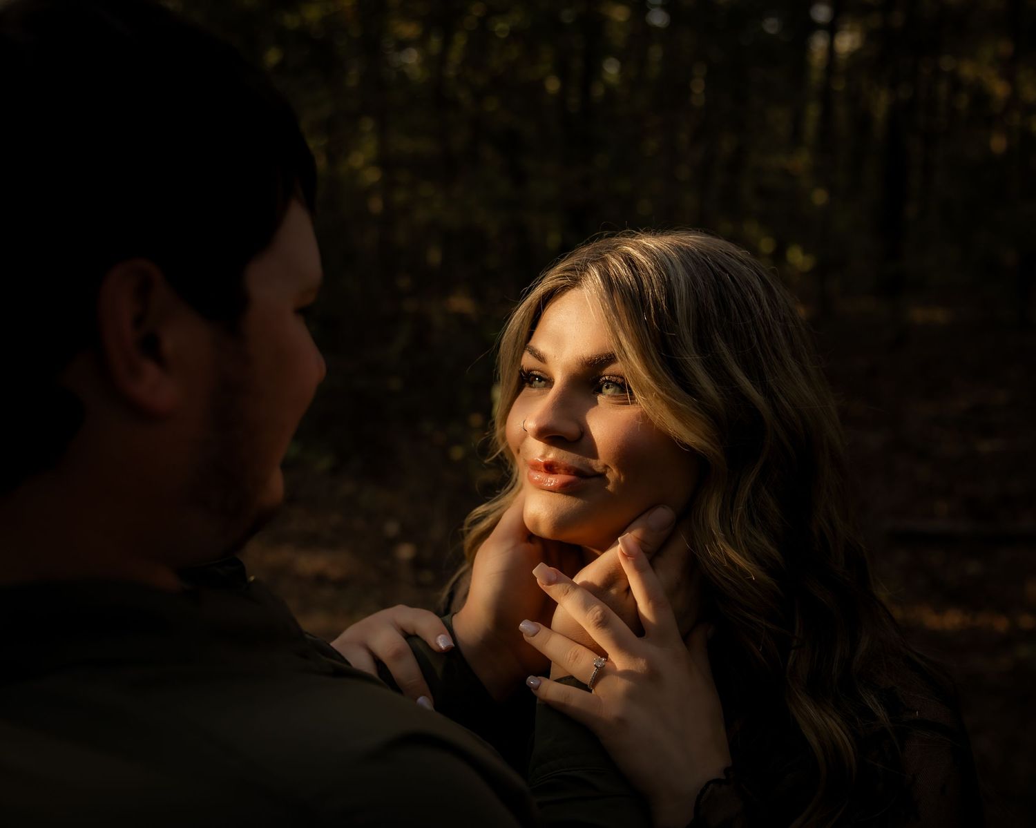Boy holding girls face and smiling at each other