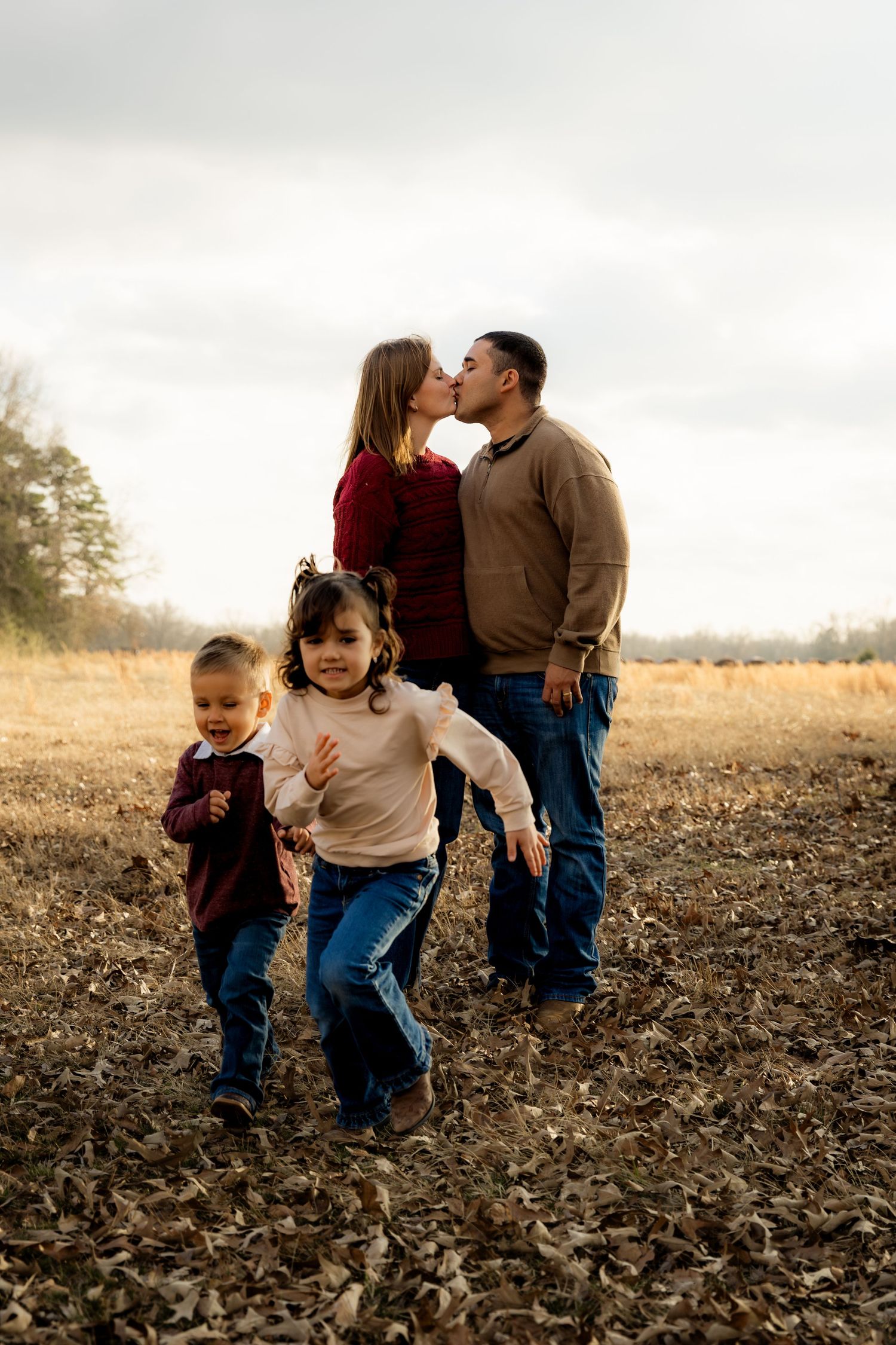 Two parents kissing and children running