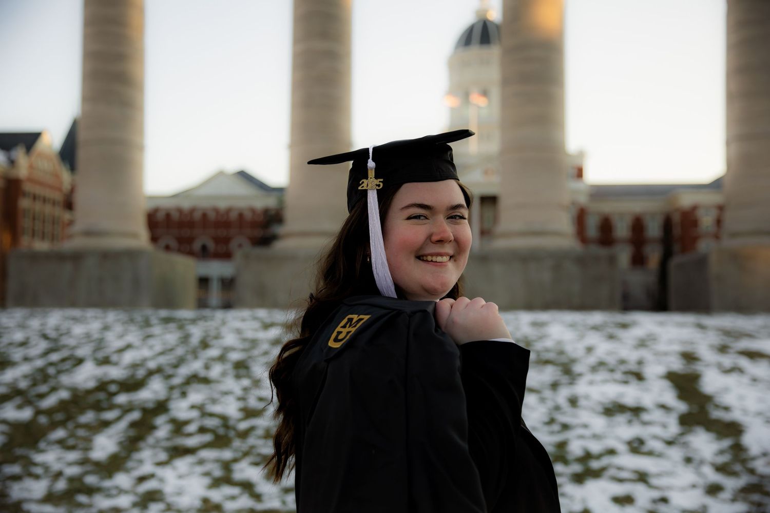 Girl holding stole with grad cap on at Mizzou and smiling