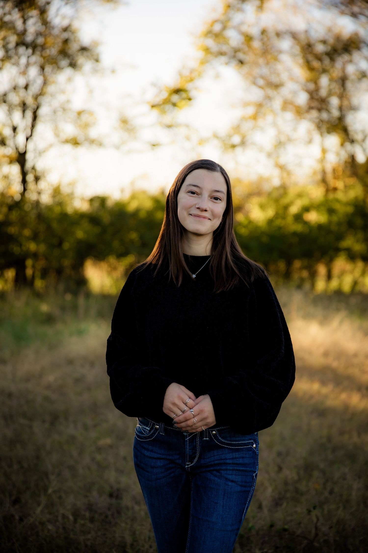 Girl smiling at camera and holding hands in front of her