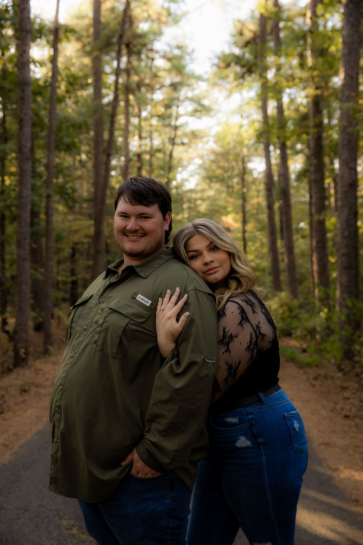 Leaning on fiance and smiling at camera
