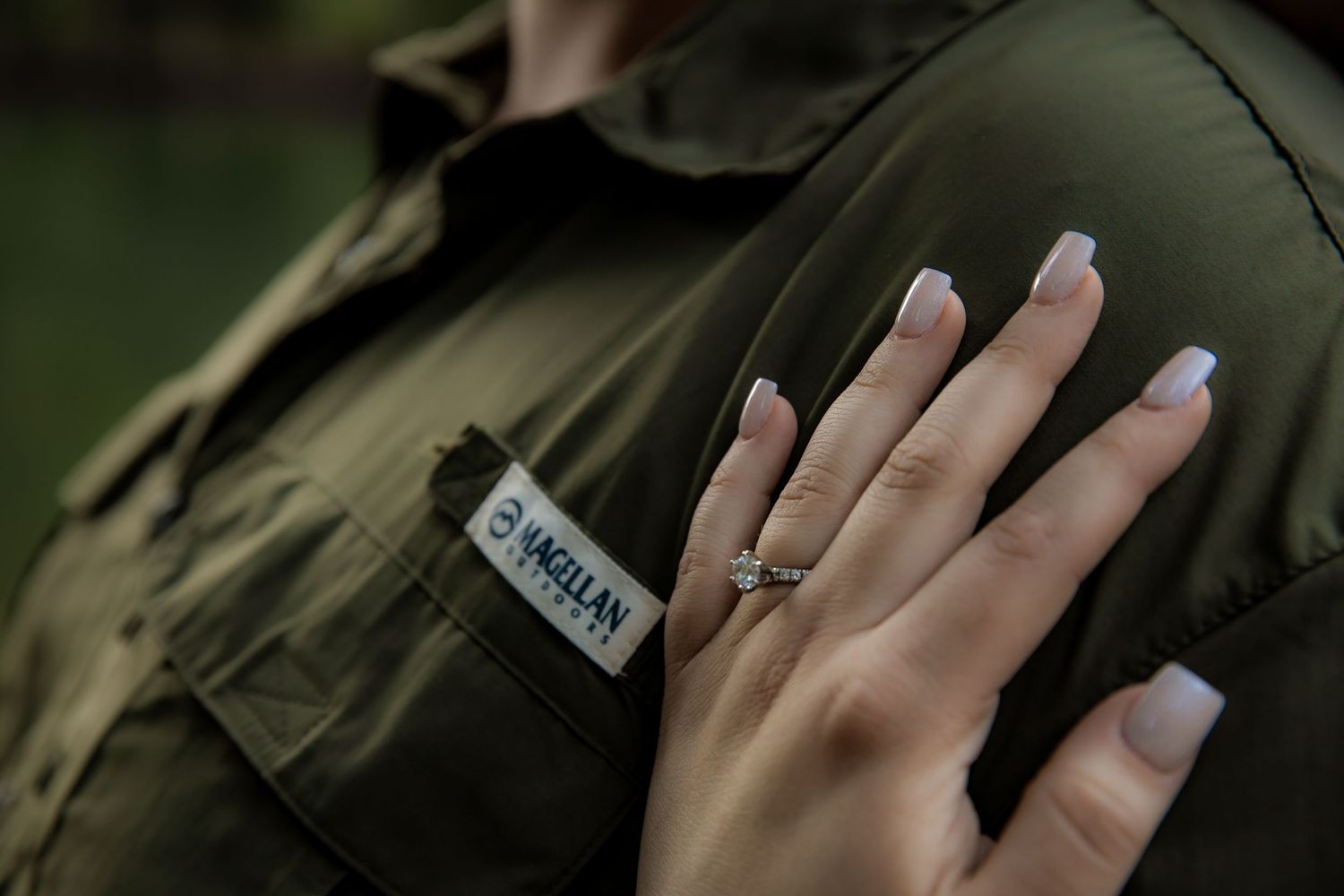 engagement ring with hand on shirt