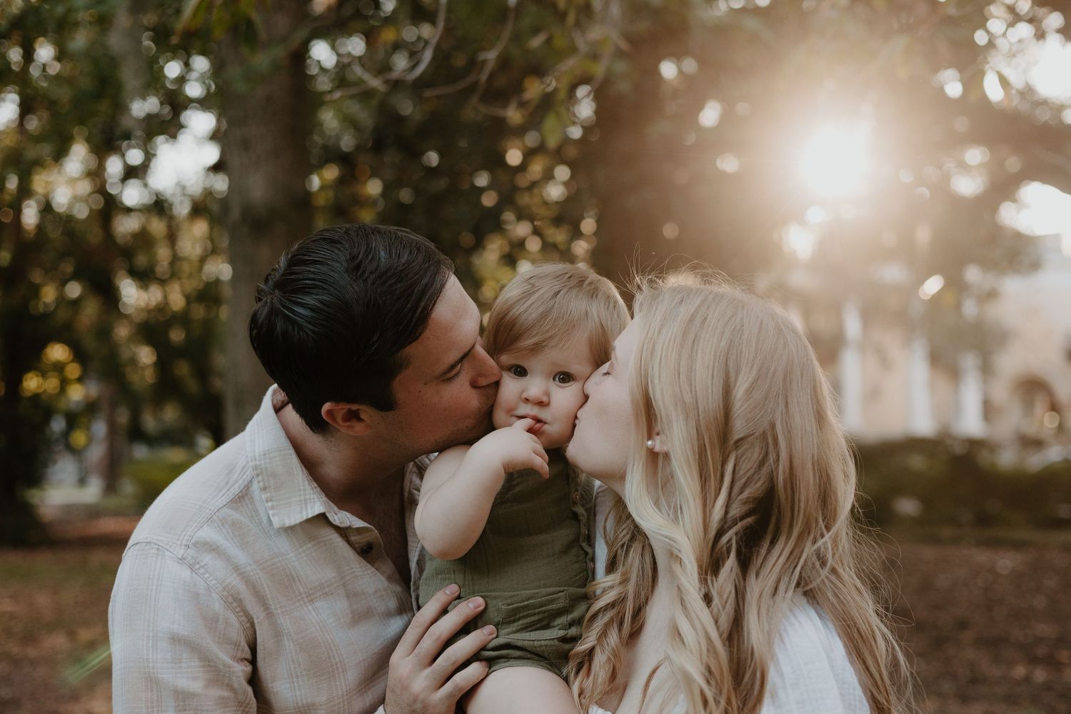 A couple shares an intimate moment during golden hour in a park setting.