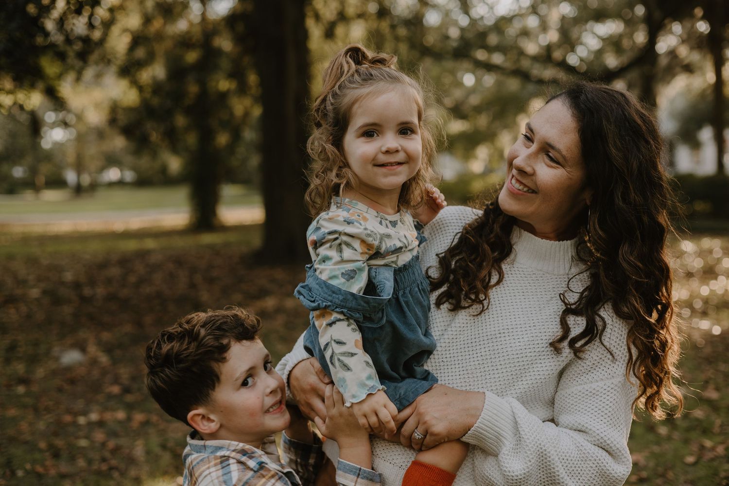 Candid family moments captured in autumn park setting with natural lighting.