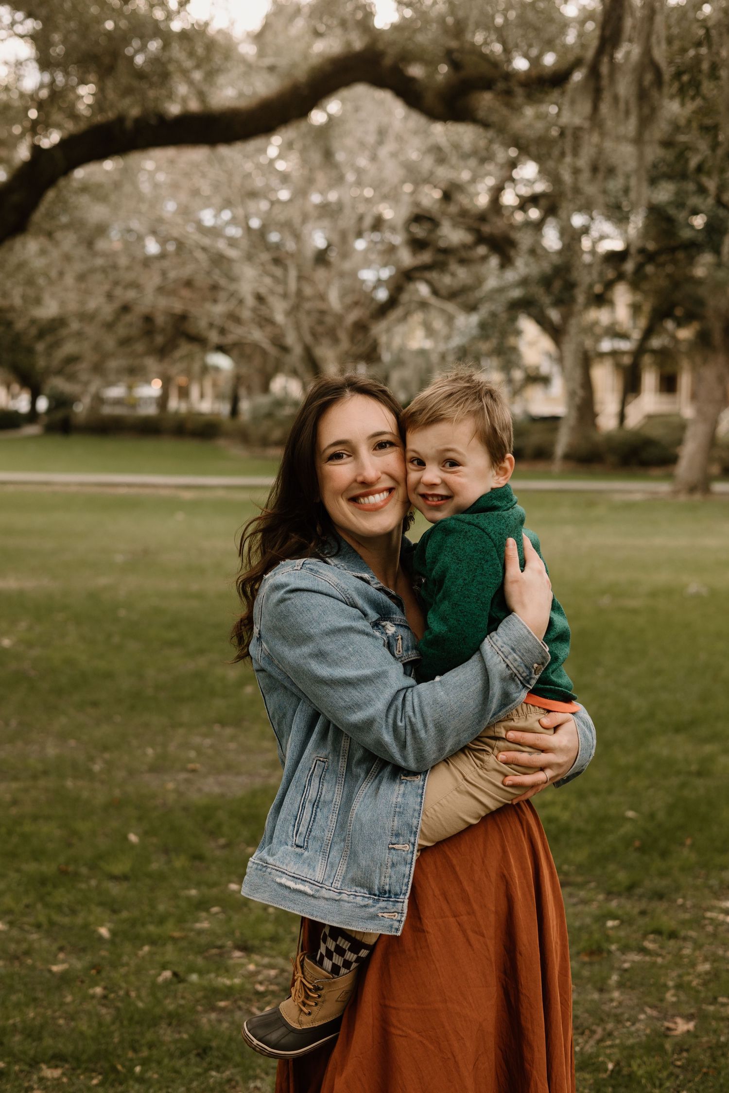 A joyful embrace captured in warm autumn light under moss-draped oak trees.