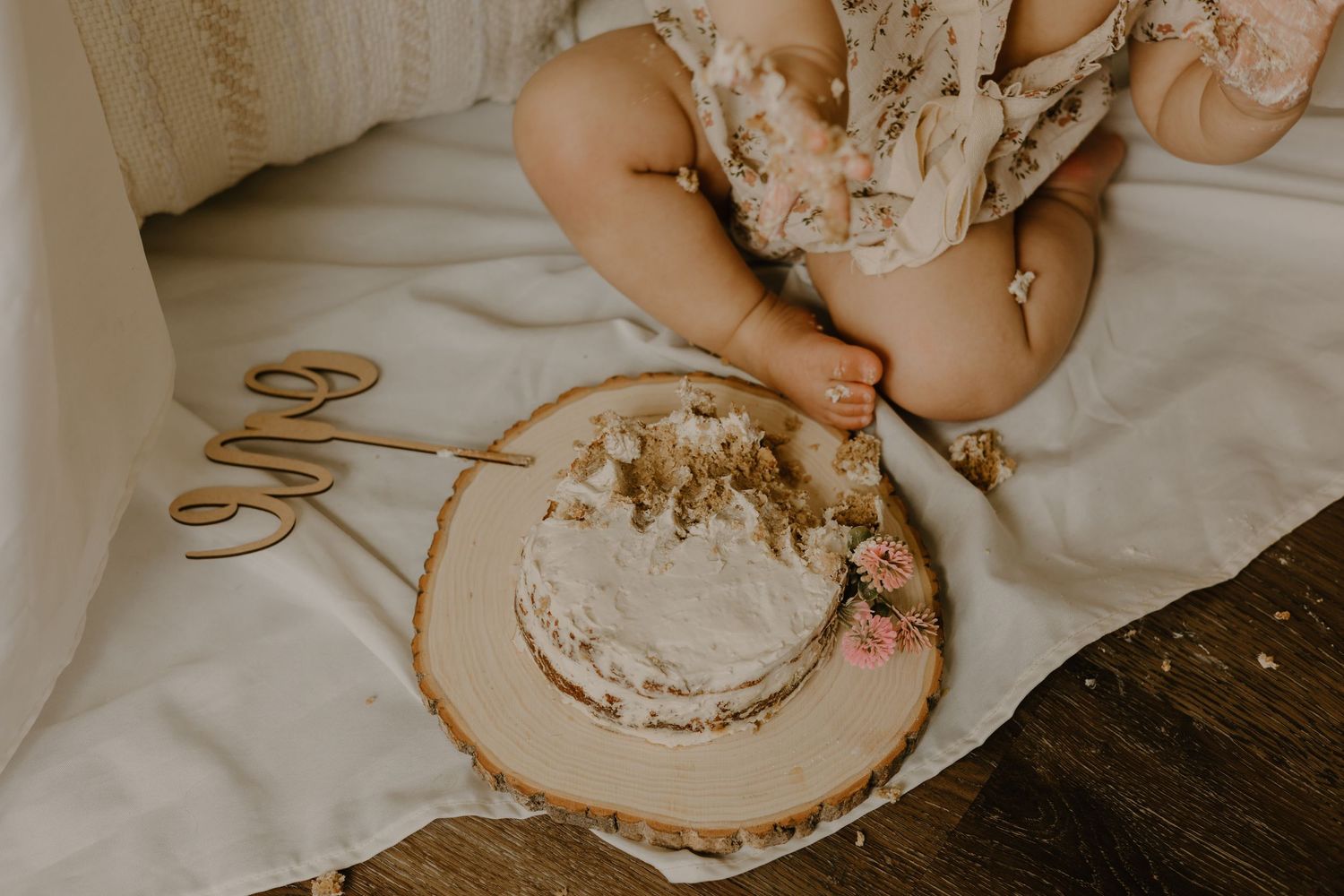 Close-up of baby's hands touching wooden decorative elements.