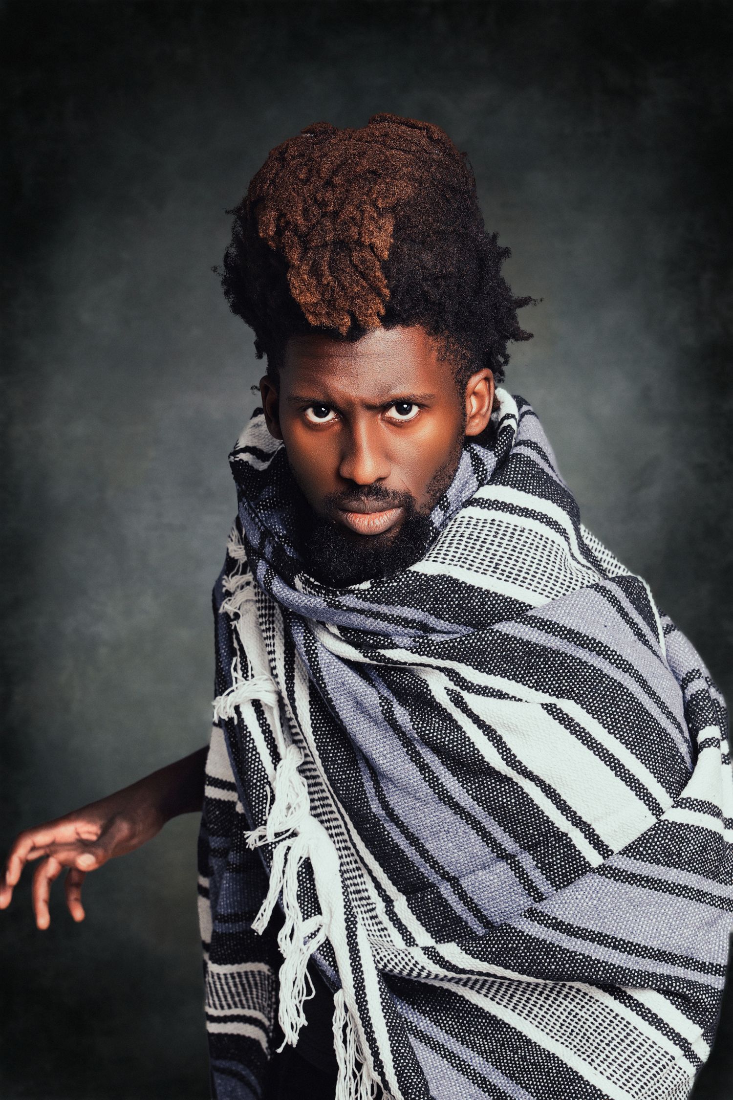Artistic portrait series featuring dramatic black and white striped wrap against dark background.