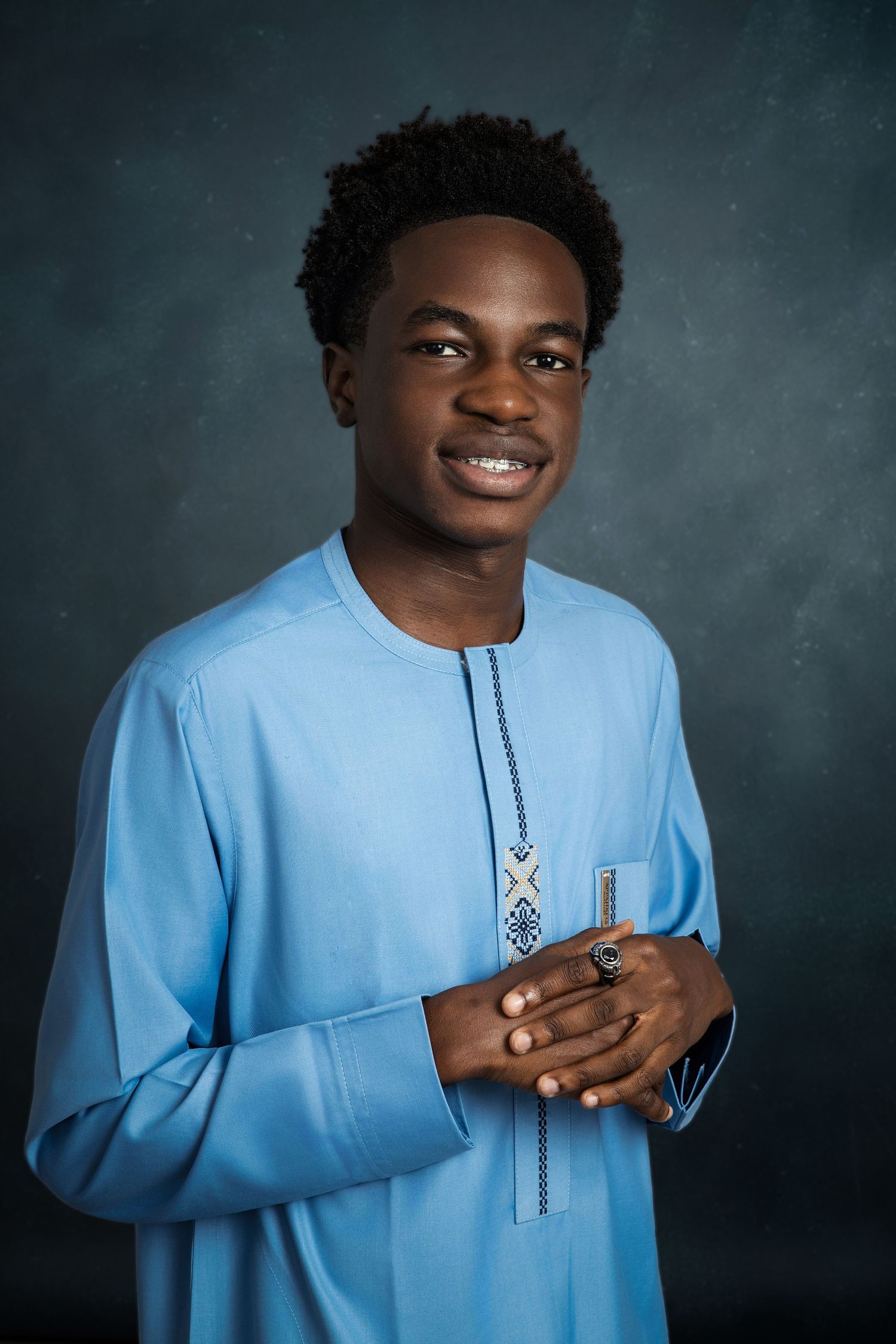 Portrait series showing someone in light blue traditional garment against dark background.