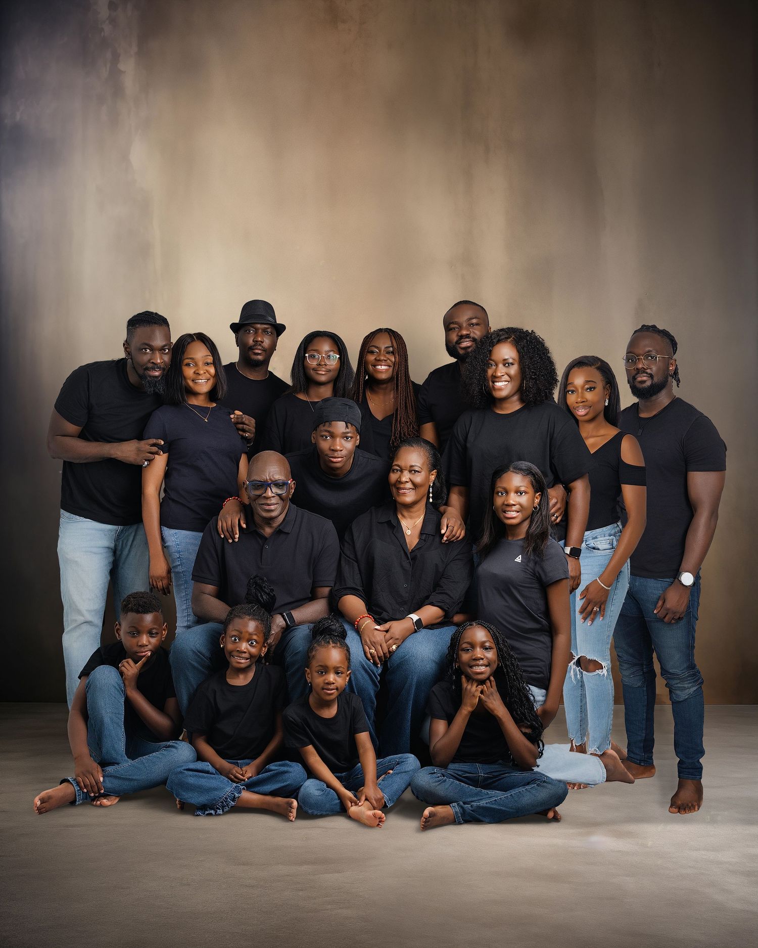 Large family portrait with multiple generations wearing coordinated black and denim outfits.