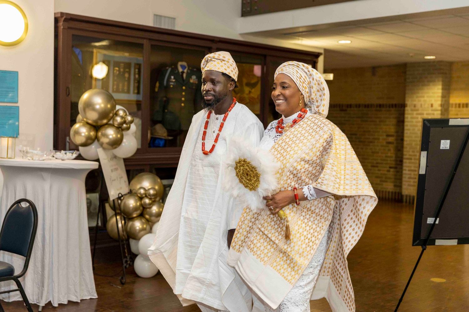 Indoor celebration decorated with gold balloons and elegant lighting creating a warm atmosphere.