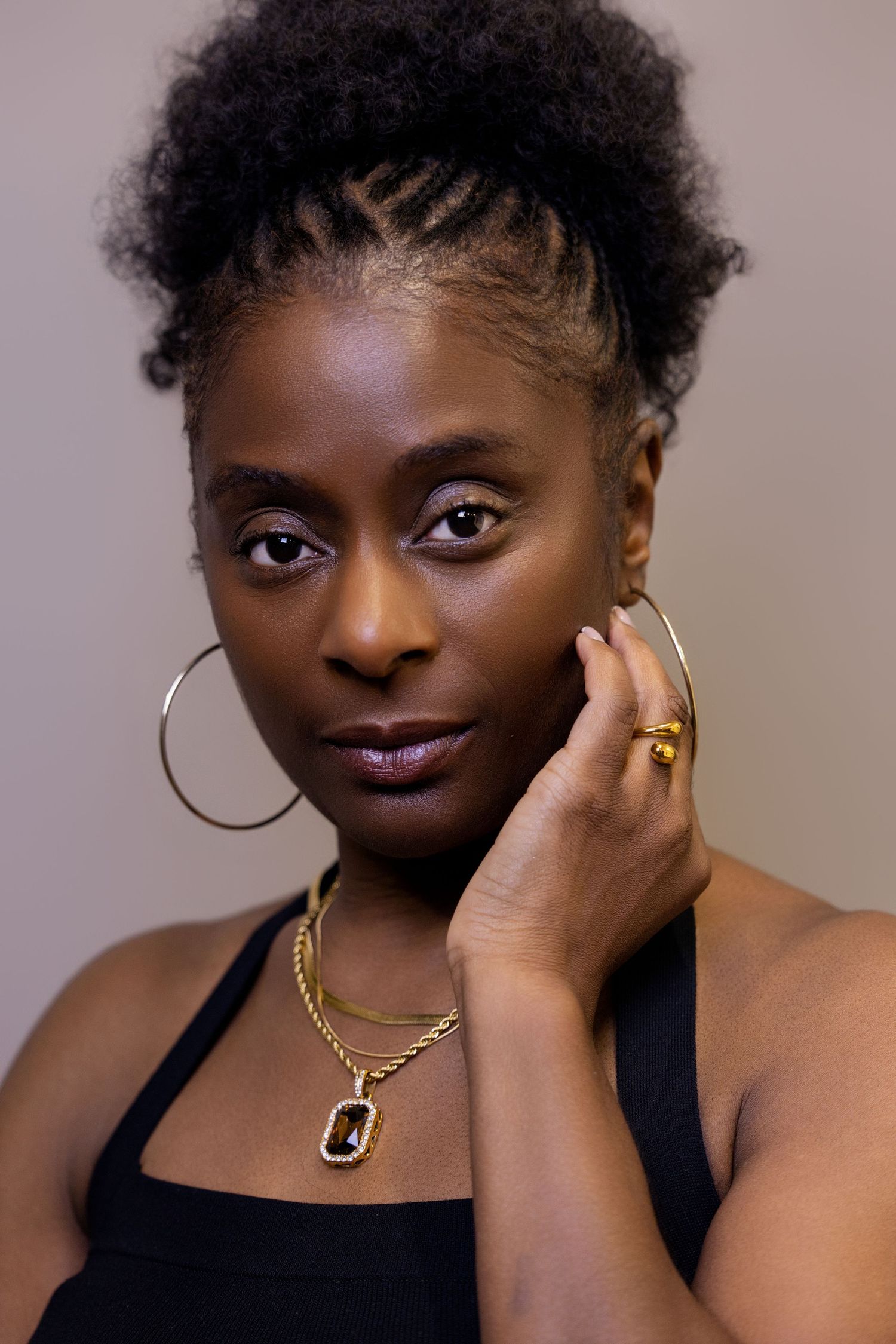 Studio portraits featuring gold jewelry and natural hair with elegant poses.