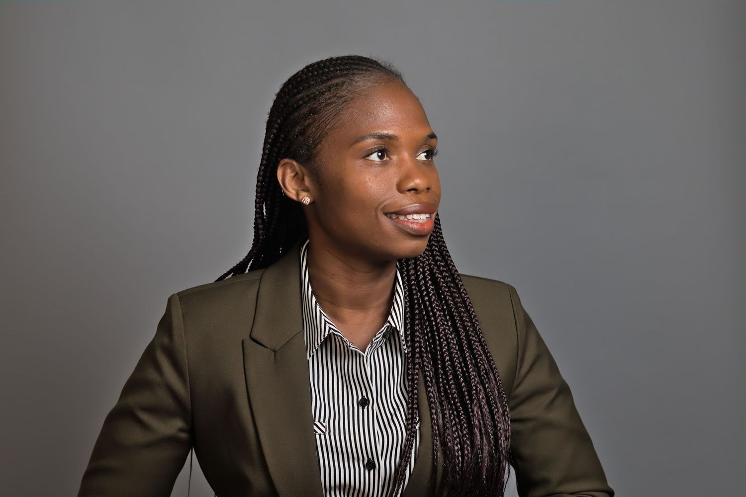 Professional headshots of someone in a striped shirt and olive blazer against a neutral backdrop.