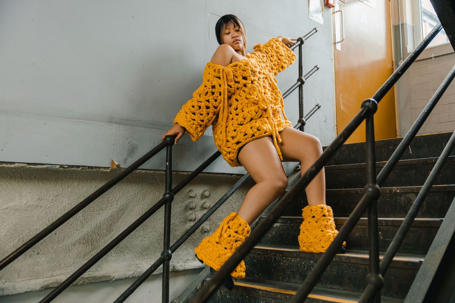 Yellow polka dot dress photographed on industrial staircase in natural light.