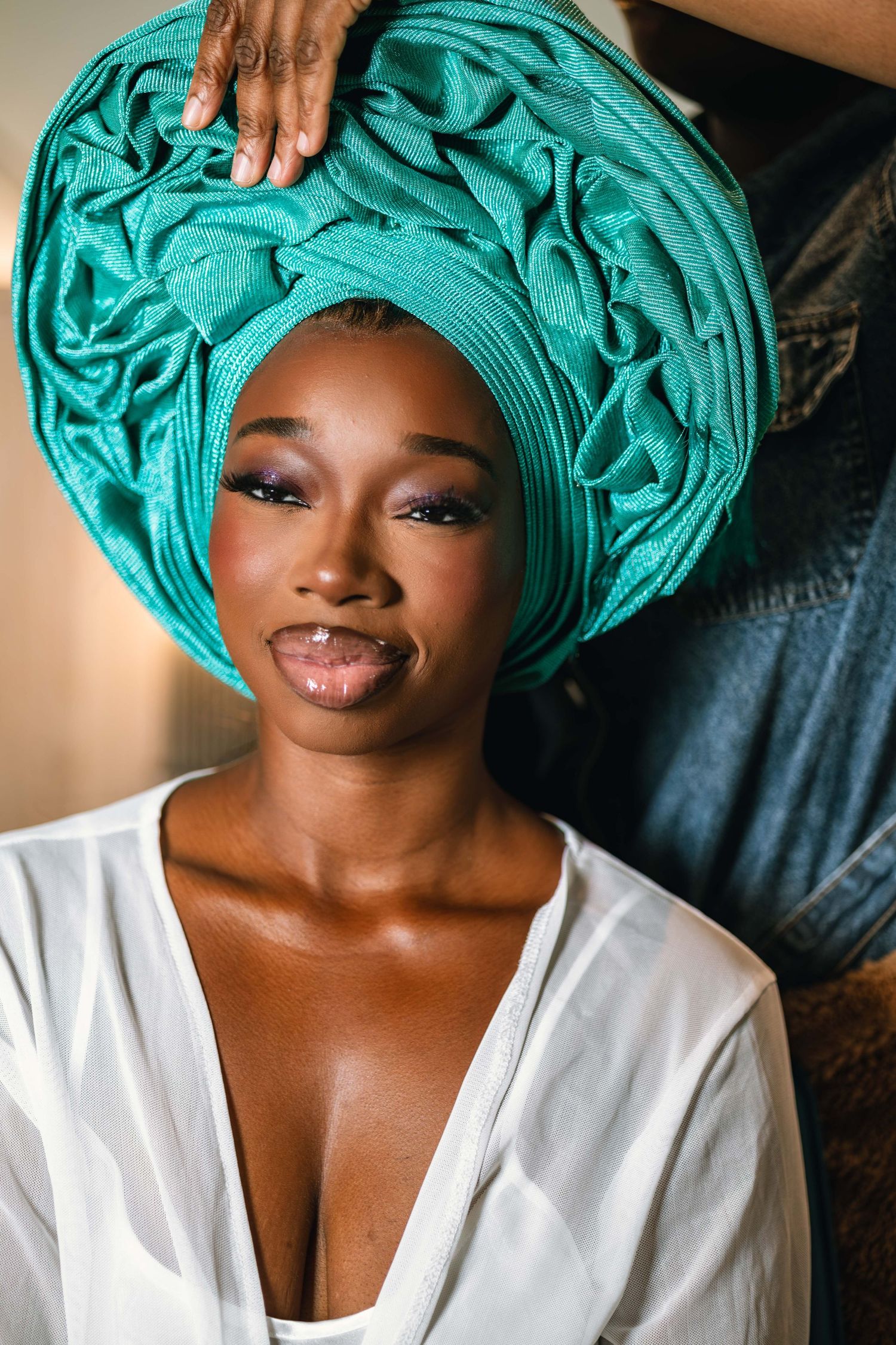 Traditional turquoise headwrap and white top styled in elegant portrait series.
