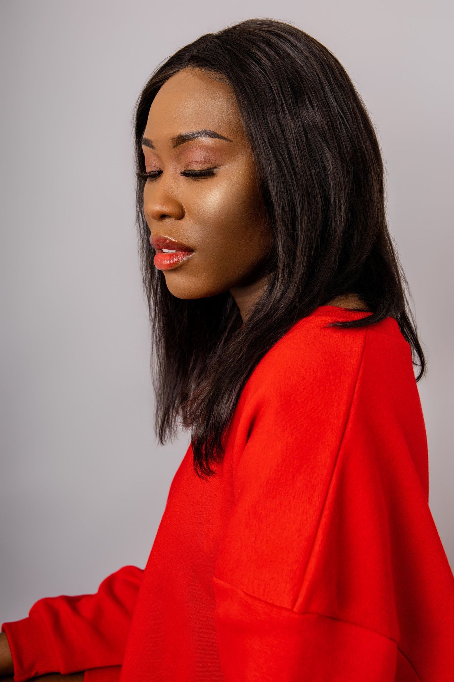 Fashion portrait series in a bright red coat with dramatic poses against gray background.