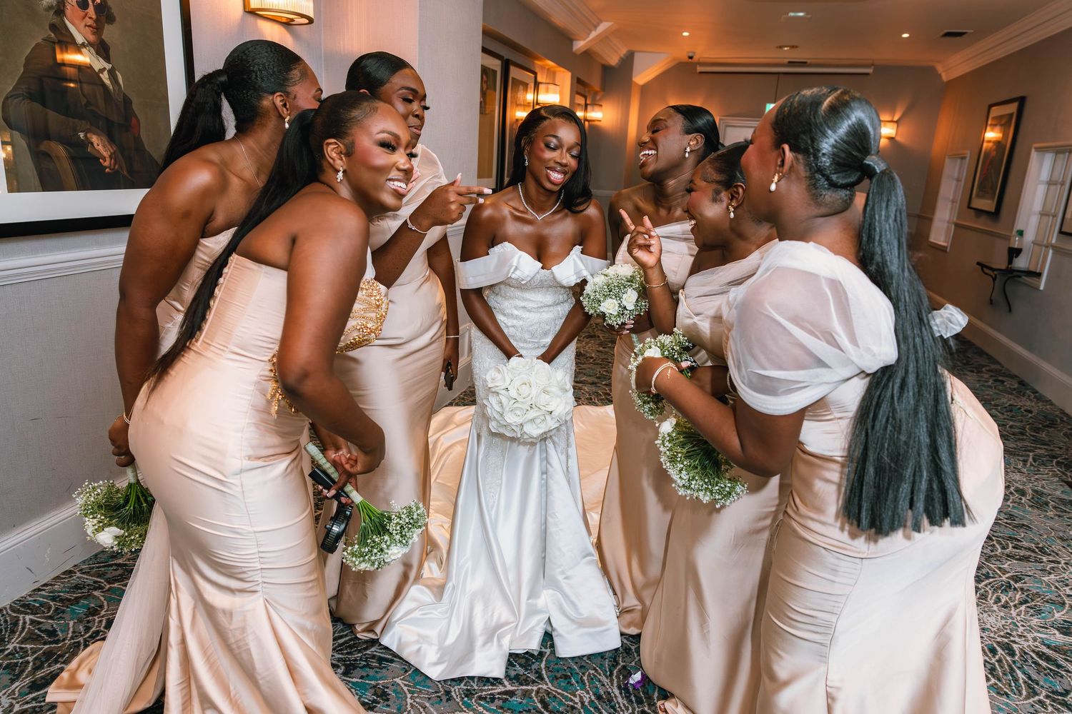 Wedding party in blush pink dresses celebrating together indoors.