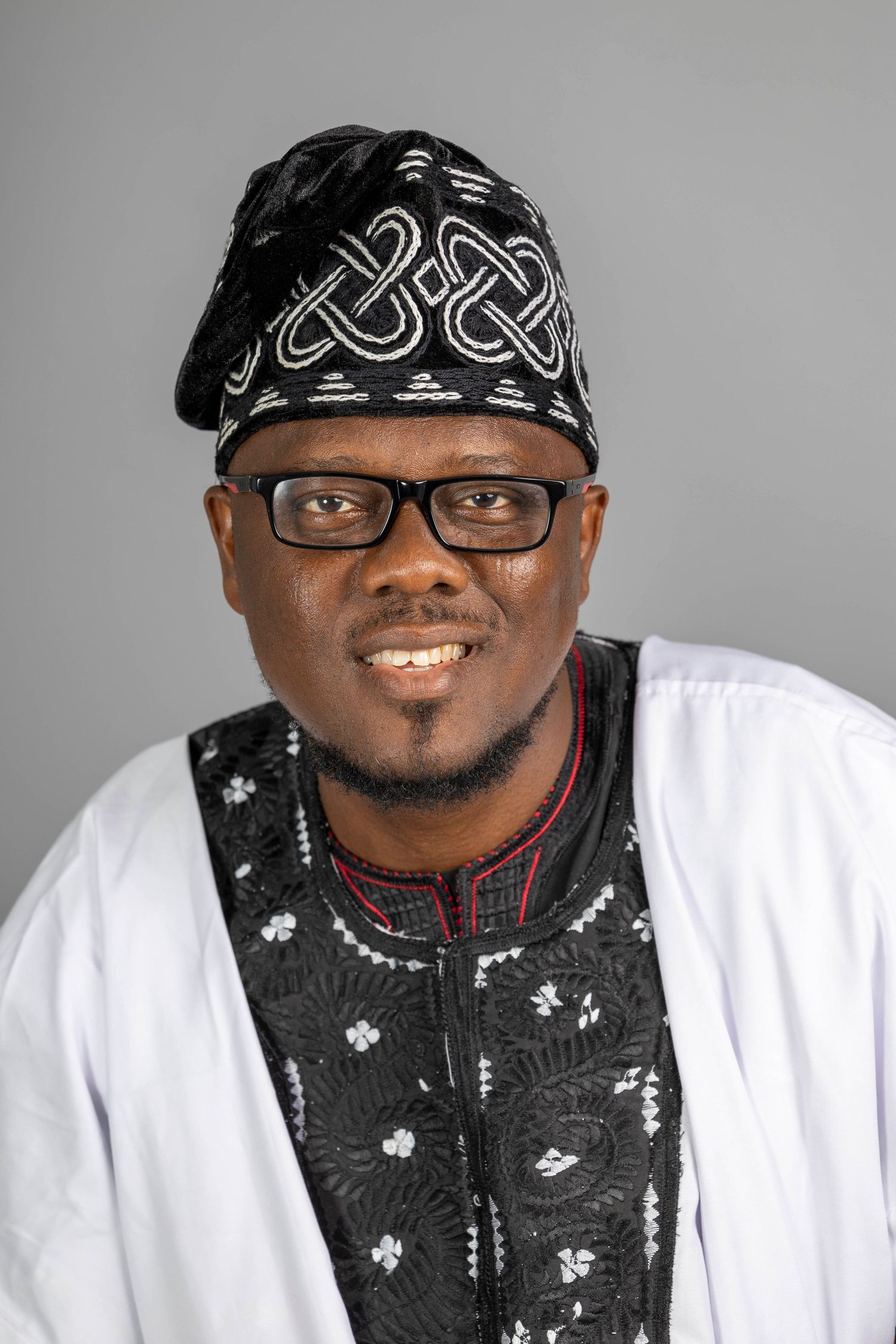 Professional studio portrait series showing a person wearing glasses and a bandana against a gray background.