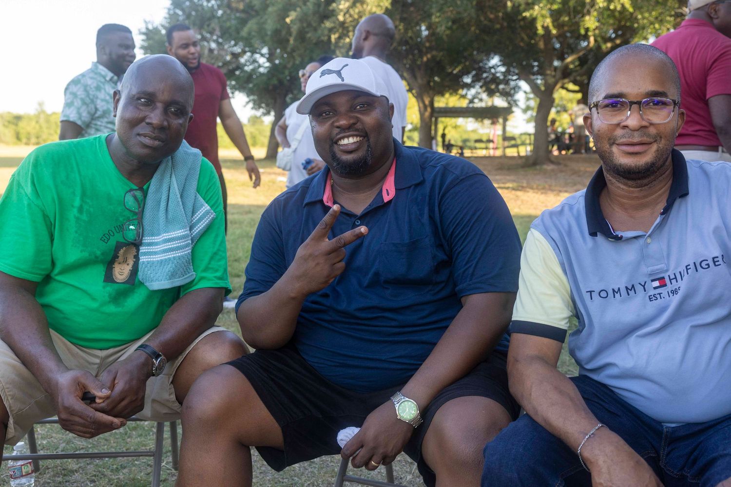 Three friends enjoying drinks at an outdoor gathering.